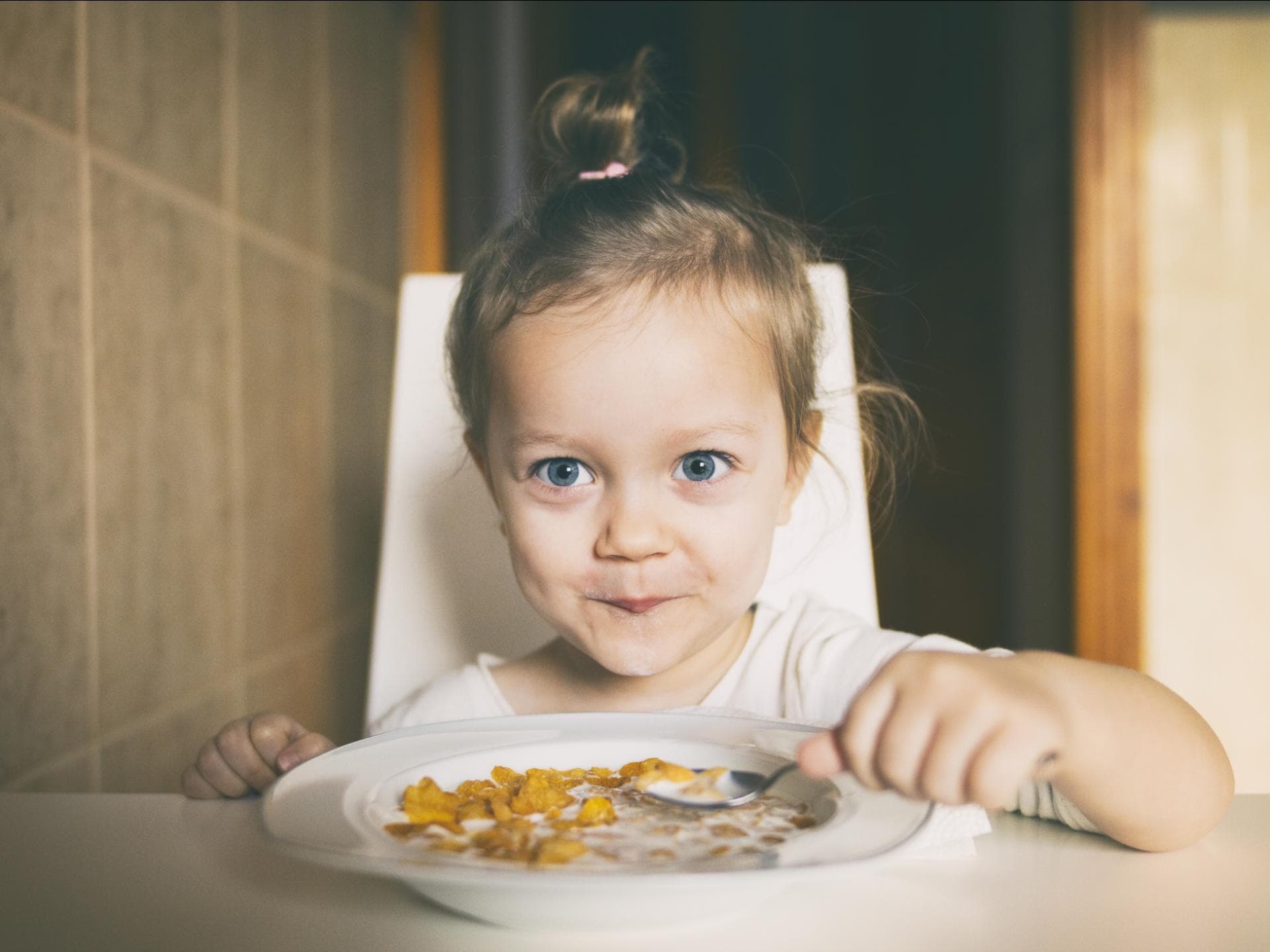 Mädchen freut sich über einen Teller Cornflakes