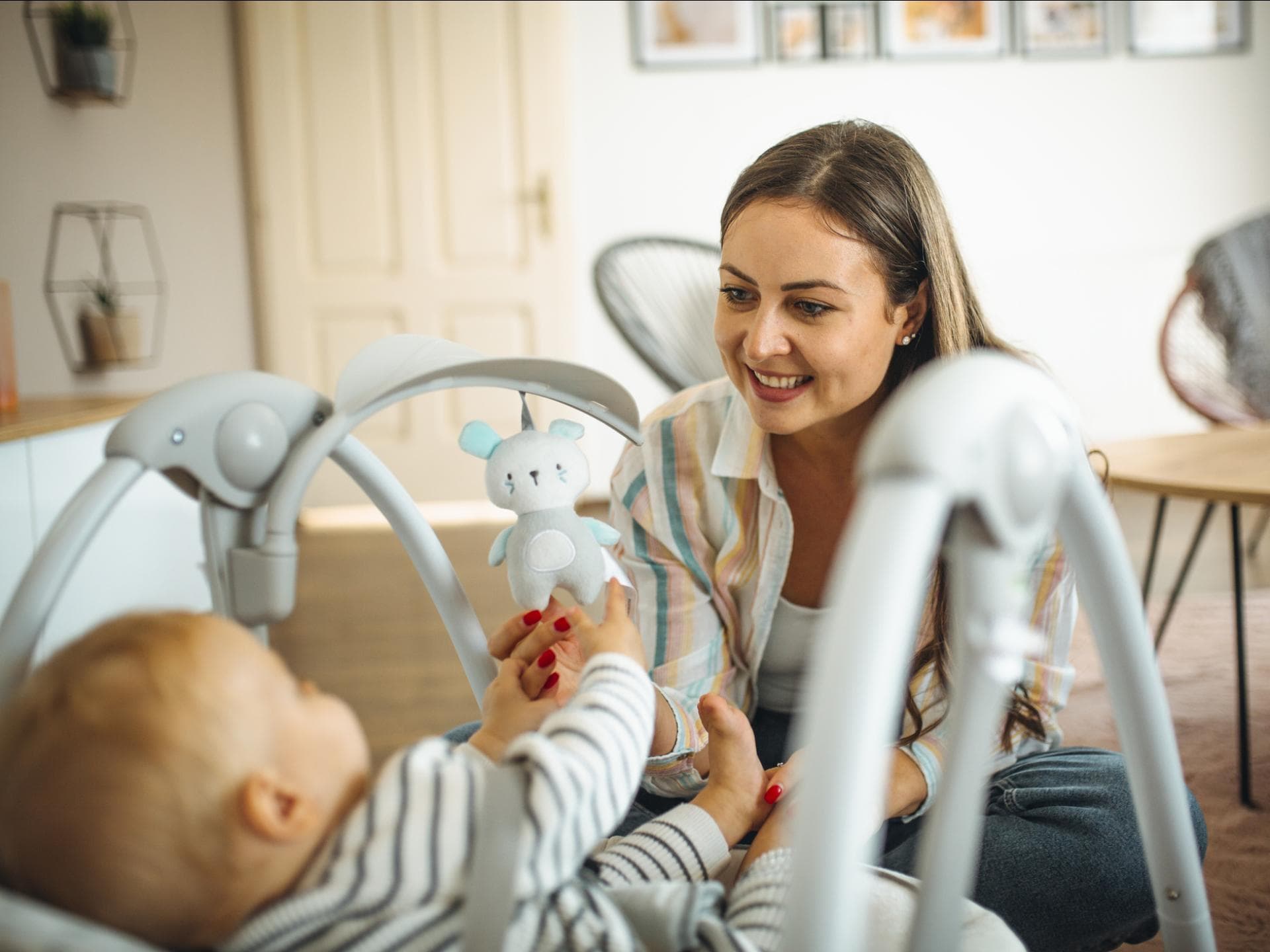 Mama schaukelt Baby in Babywippe