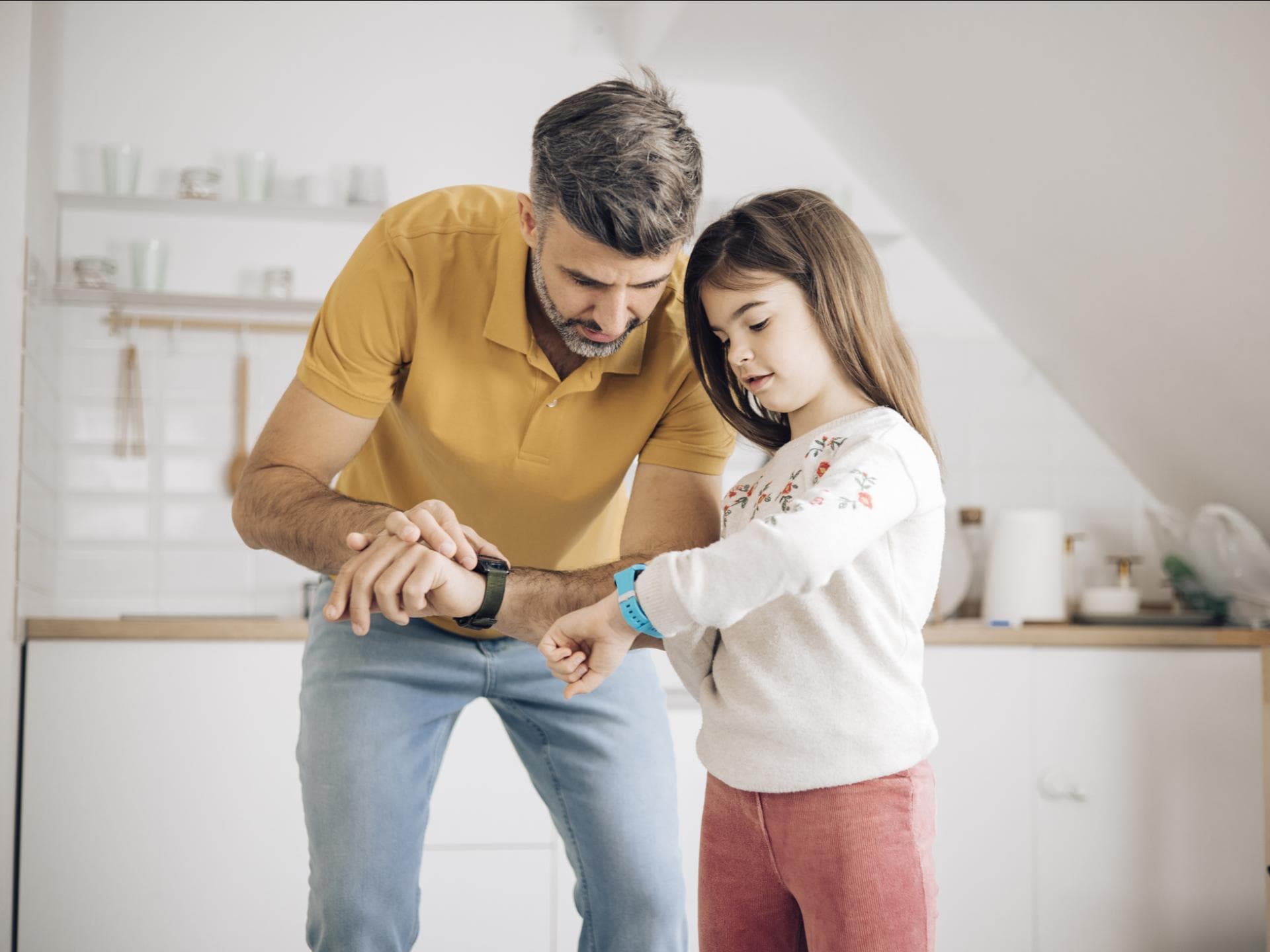 Papa und Tochter checken ihre Smartwatches