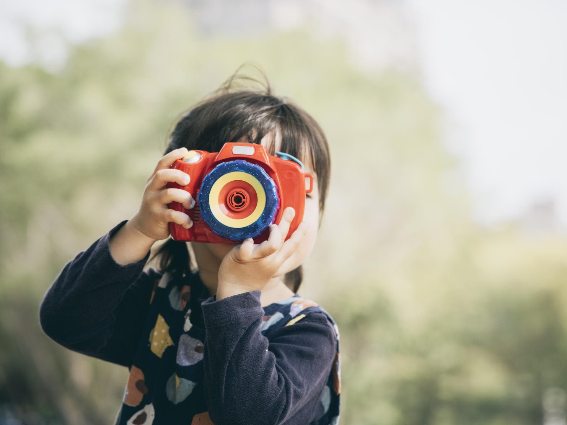 Mädchen macht Foto mit Kinderkamera Mädchen macht Foto mit Kinderkamera