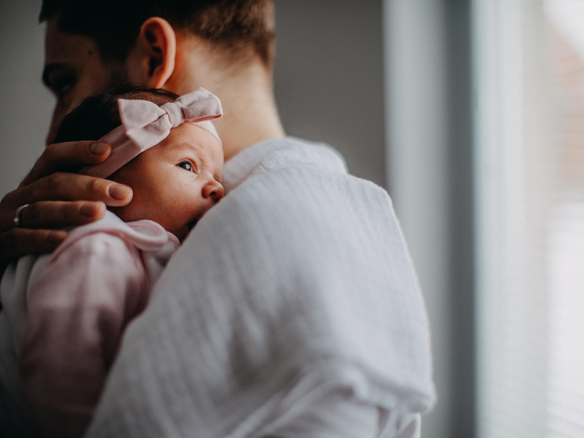 Papa hält neugeborene Tochter im Arm Papa hält neugeborene Tochter im Arm