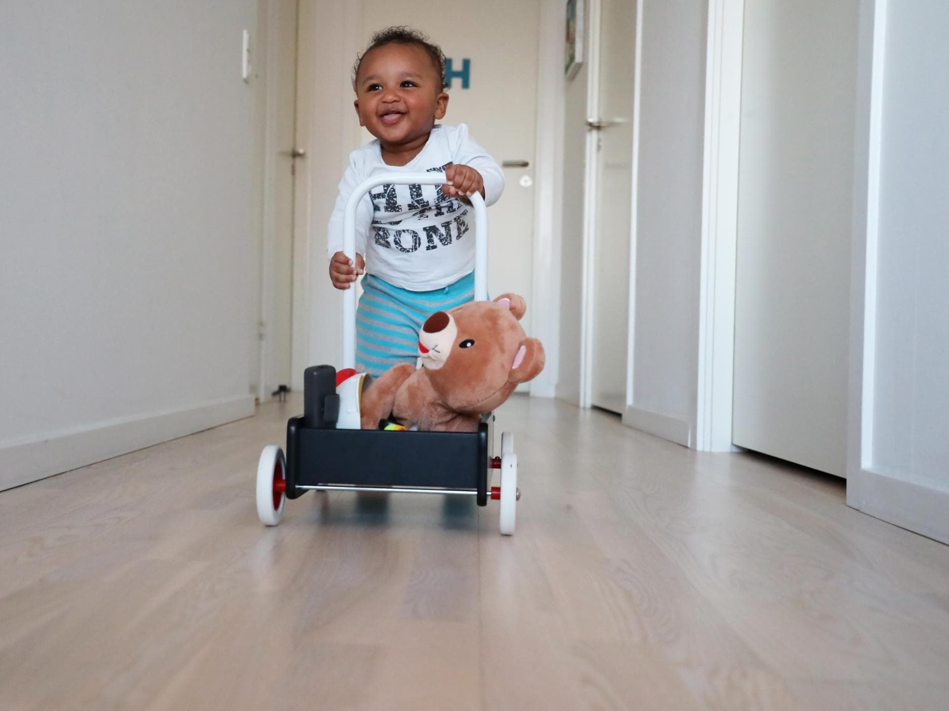 Kleiner Junge lernt laufen am Lauflernwagen