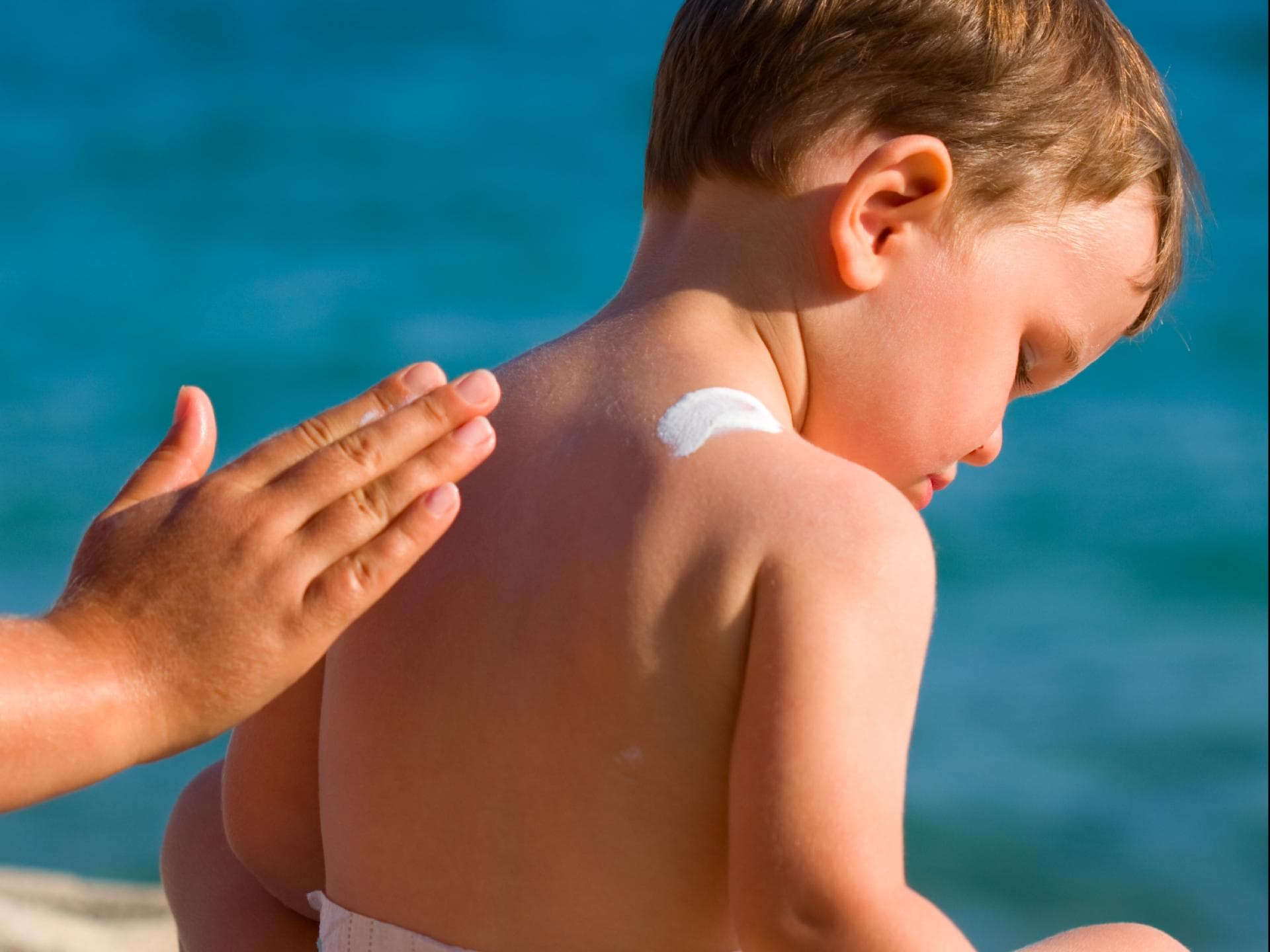 Unbedingt zu vermeiden: Sonnenbrand bei Babys und Kleinkindern Ein Kleinkind wird mit Sonnencreme eingecremt.