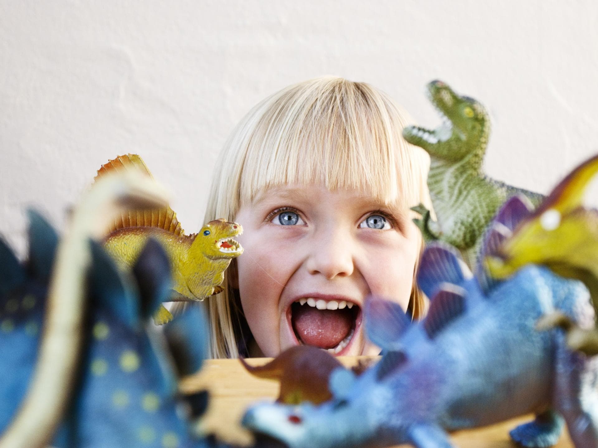 Überall lauern sie: Die Mitgebsel für Kinder. Kleines Mädchen mit Spielzeug Dinos