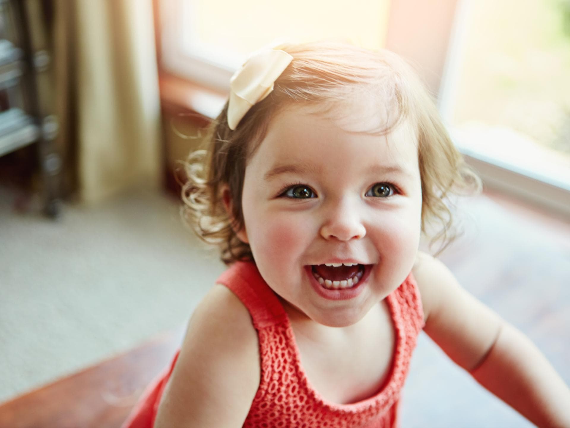 Kleines Baby-Mädchen lacht im hellen Licht der Sonne Kleines Baby-Mädchen lacht im hellen Licht der Sonne