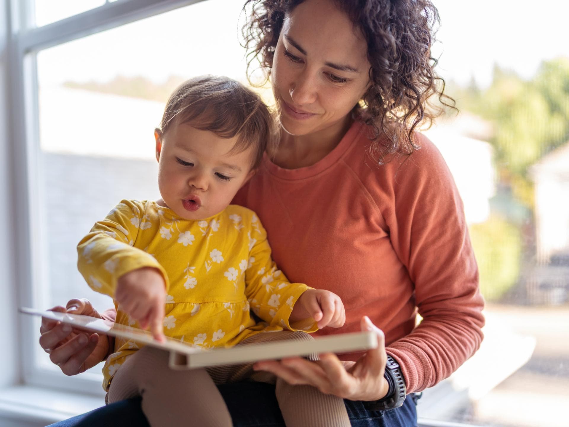 Mama und Kleinkind schauen sich ein Buch an Mama und Kleinkind schauen sich ein Buch an