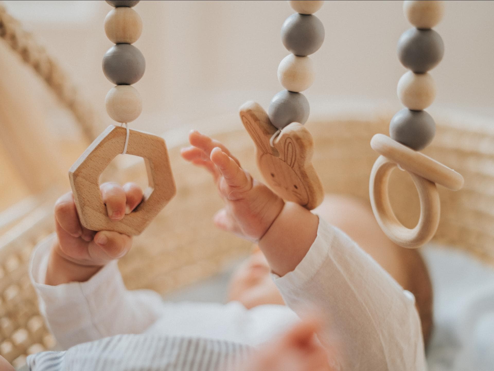 Baby spielt mit Holz-Mobile