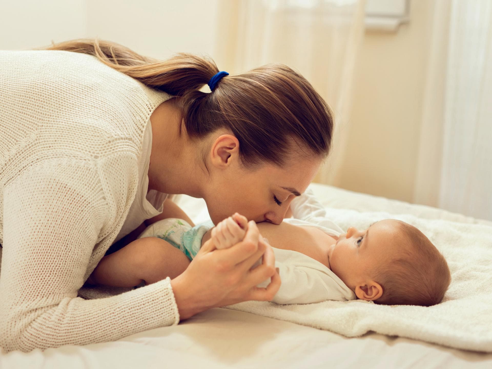 Mama kuschelt mit Baby beim Wickeln
