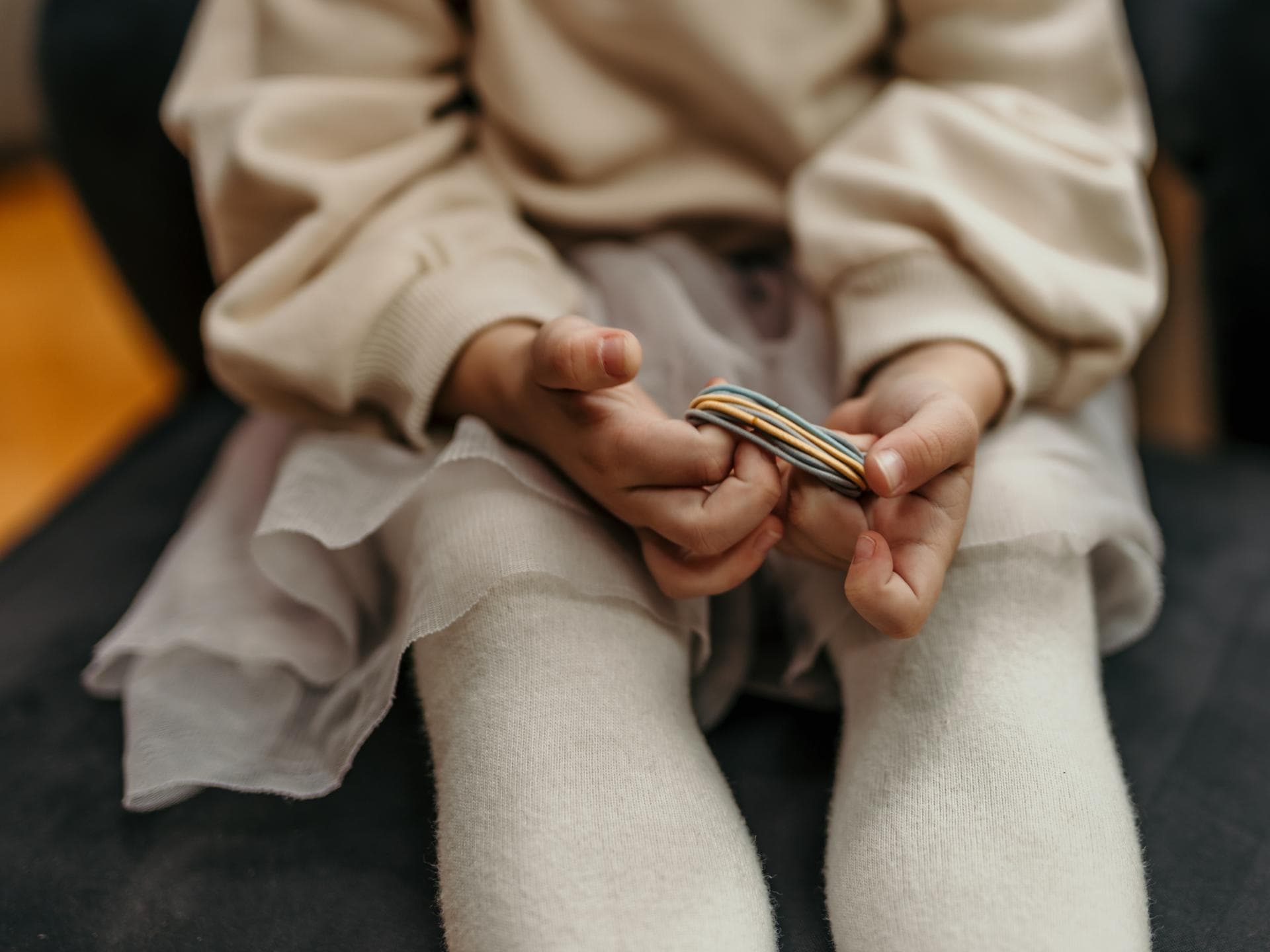 Mädchen hält Haargummis in der Hand