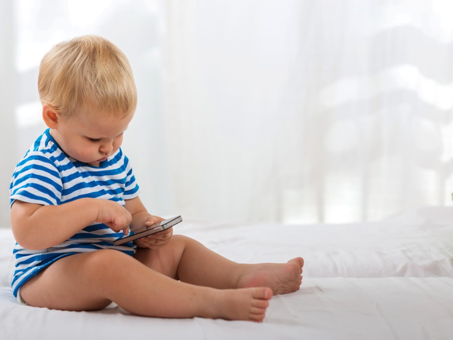 Baby tippt auf Handy rum