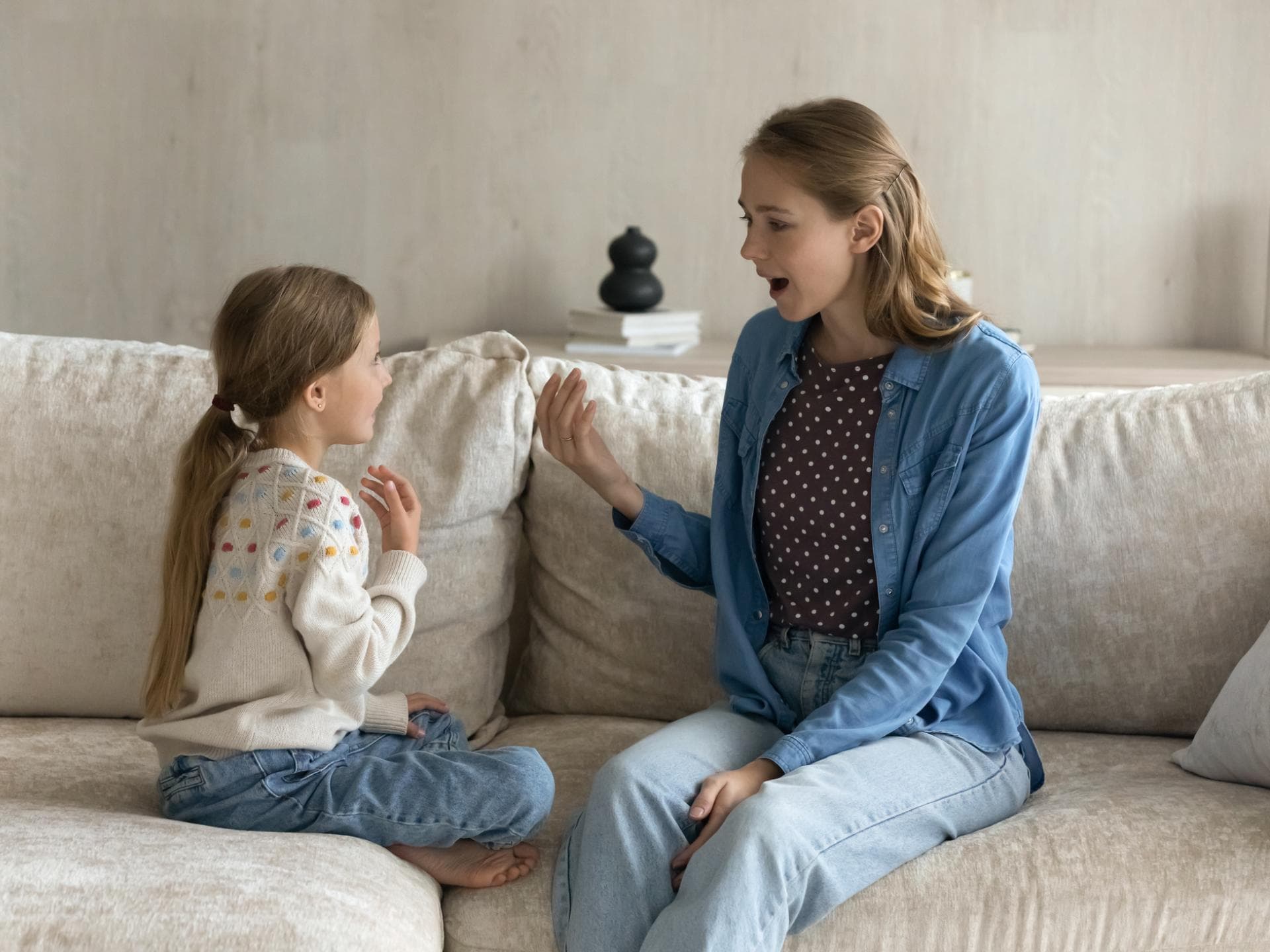 Mutter und Tochter unterhalten sich auf dem Sofa. Mutter und Tochter unterhalten sich auf dem Sofa.