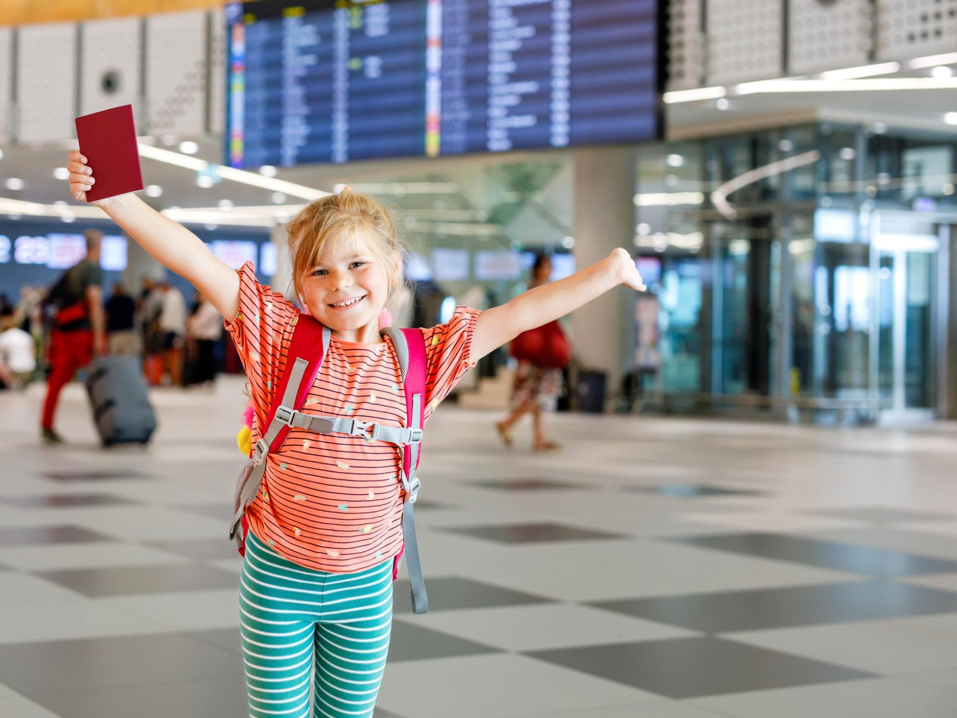 Kleines Mädchen mit Kinderreisepass am Flughafen