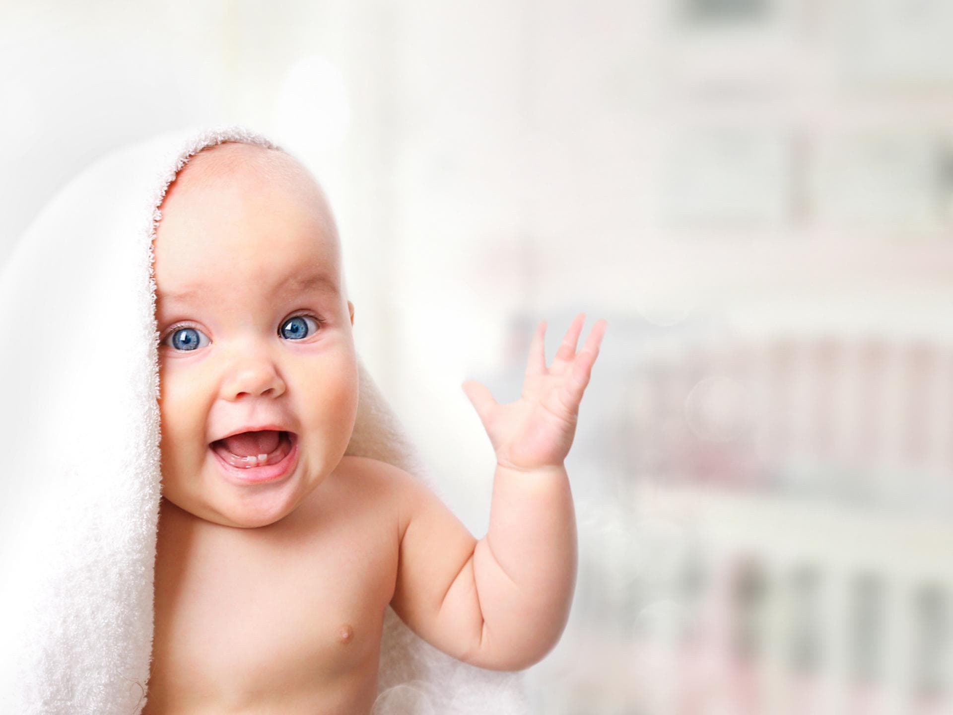 Lachendes Baby unter Handtuch.