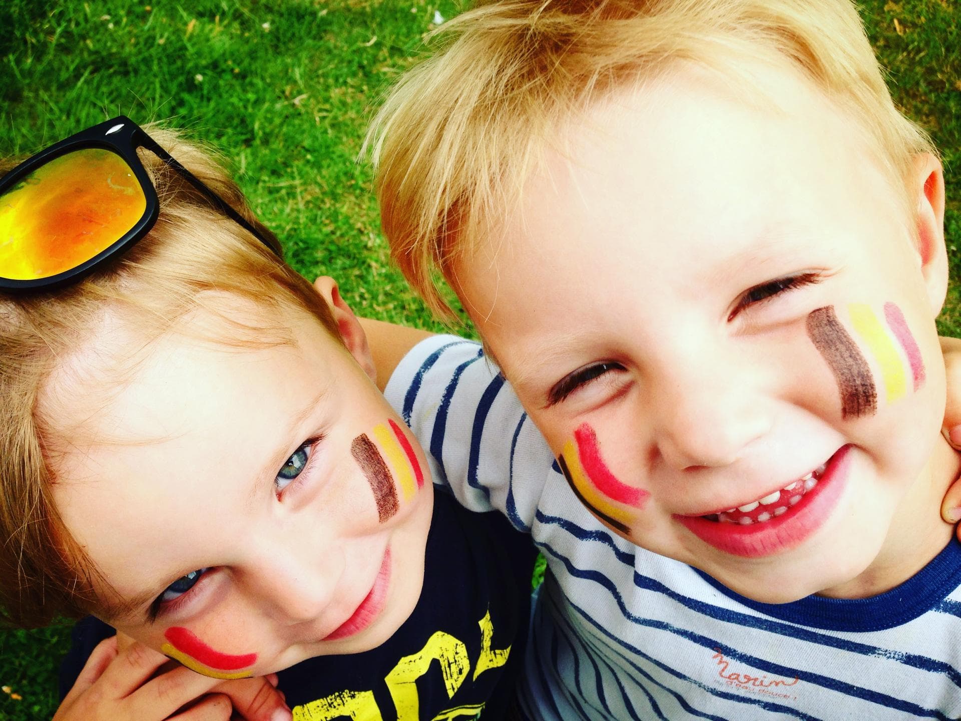 Zwei belgische Kinder mit aufgemalter Flagge auf den Wangen