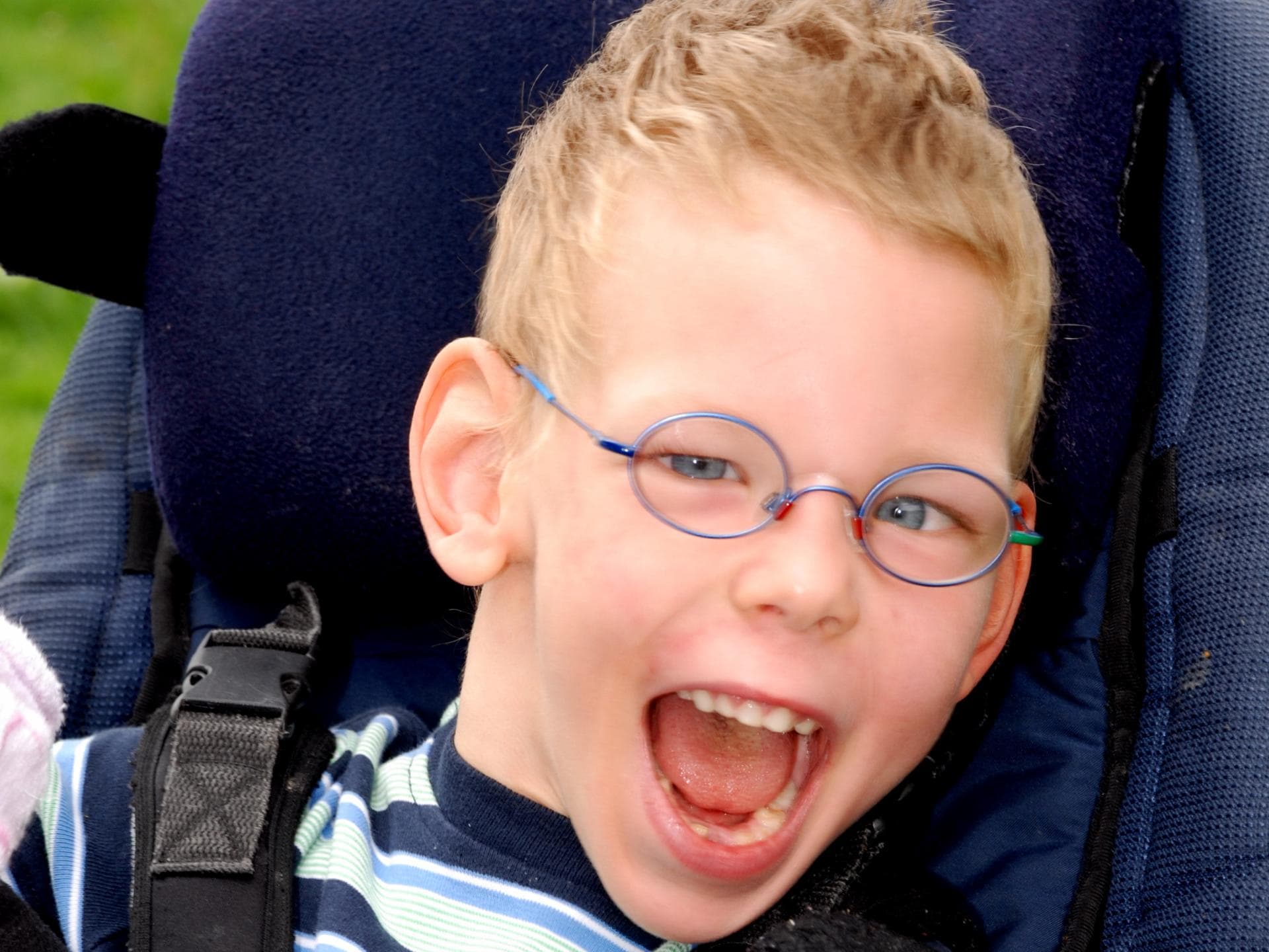 Lachendes Kind im Kindersitz Lachendes Kind im Kindersitz