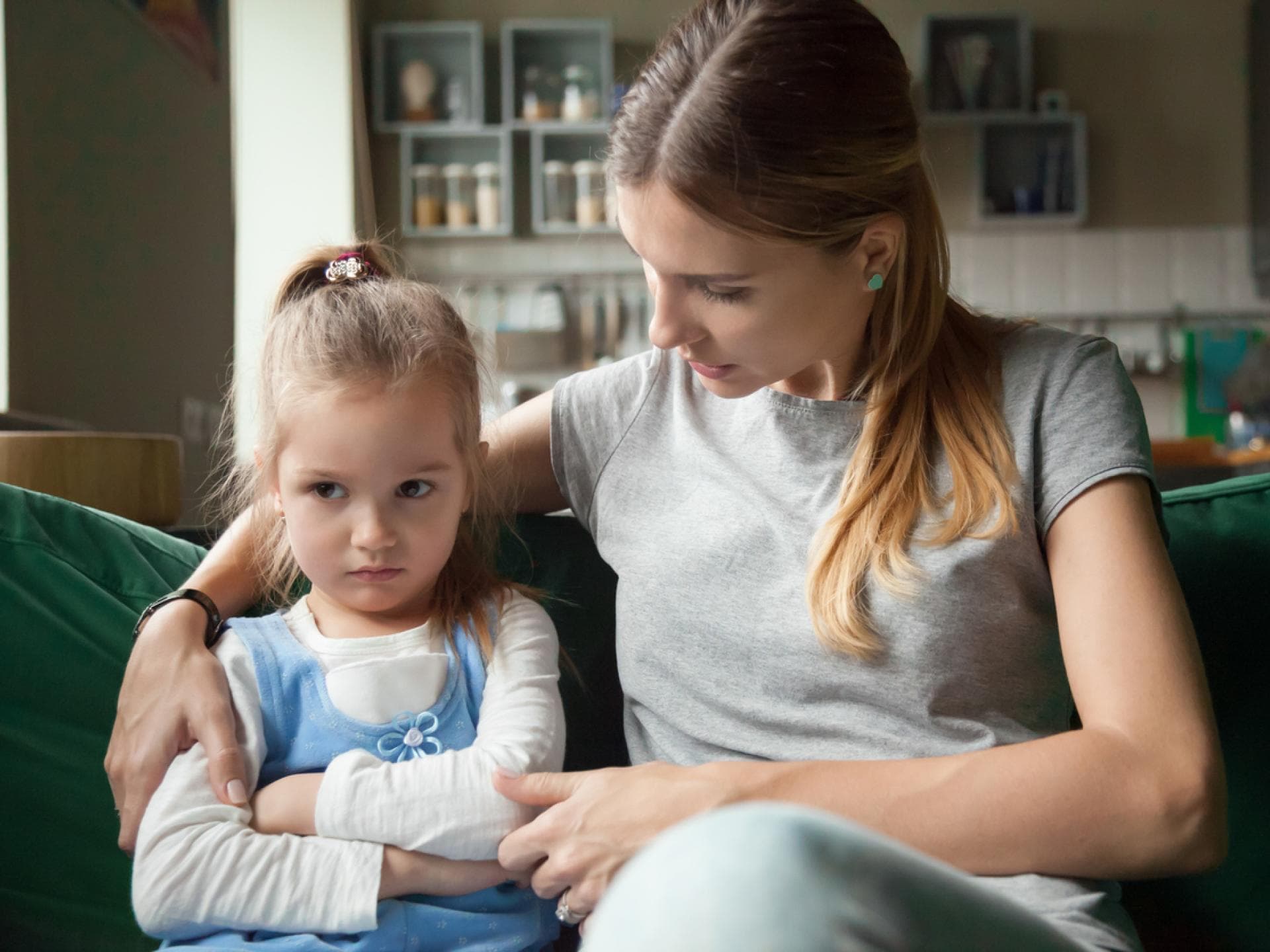 Junge Mutter spricht einfühlsam und liebevoll mit ihrer kleinen Tochter. 