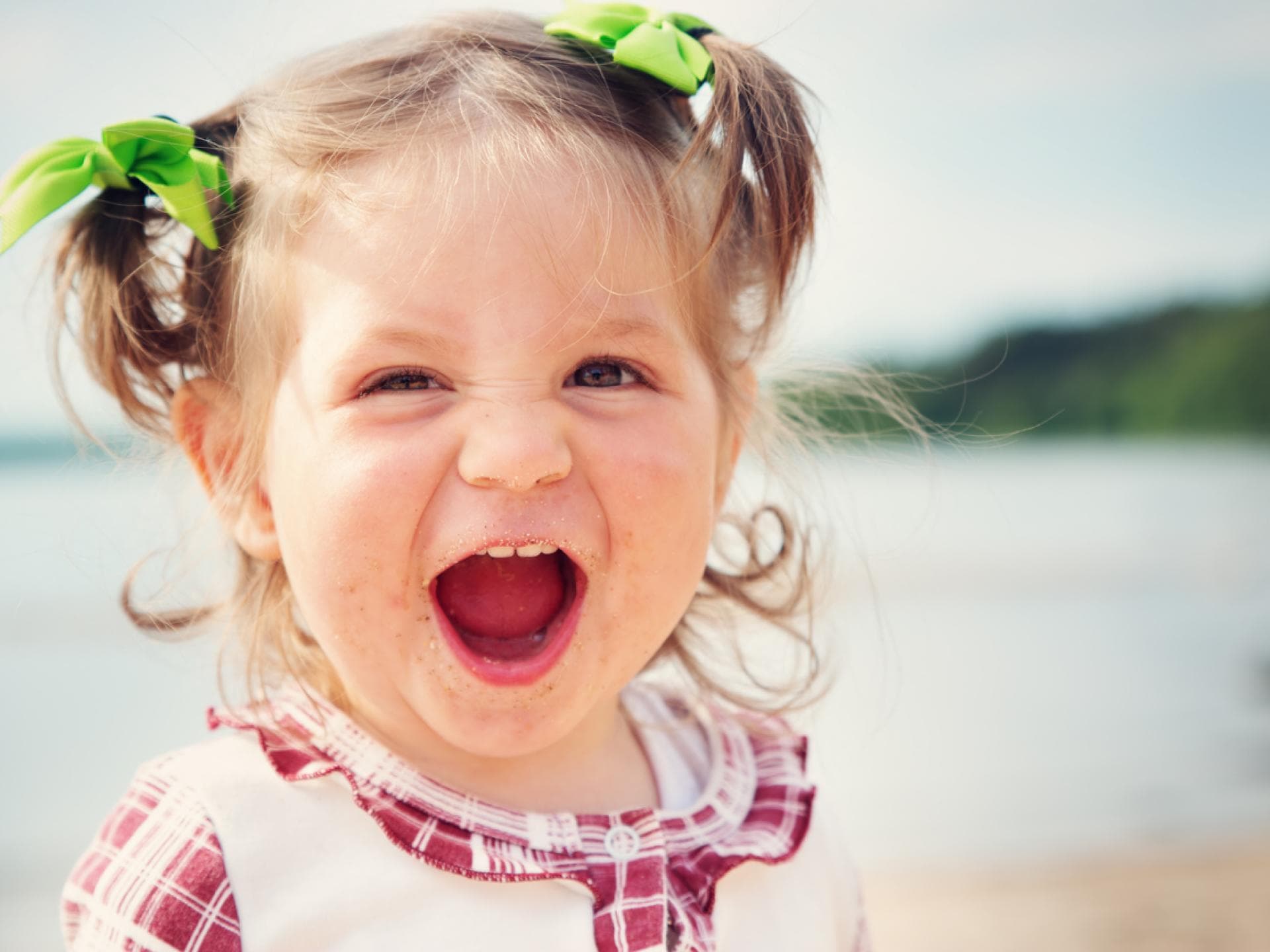 Kleines niedliches Baby-Mädchen lacht am Strand und freut sich über ihren starken Namen. Kleines niedliches Baby-Mädchen lacht am Strand und freut sich über ihren starken Namen.