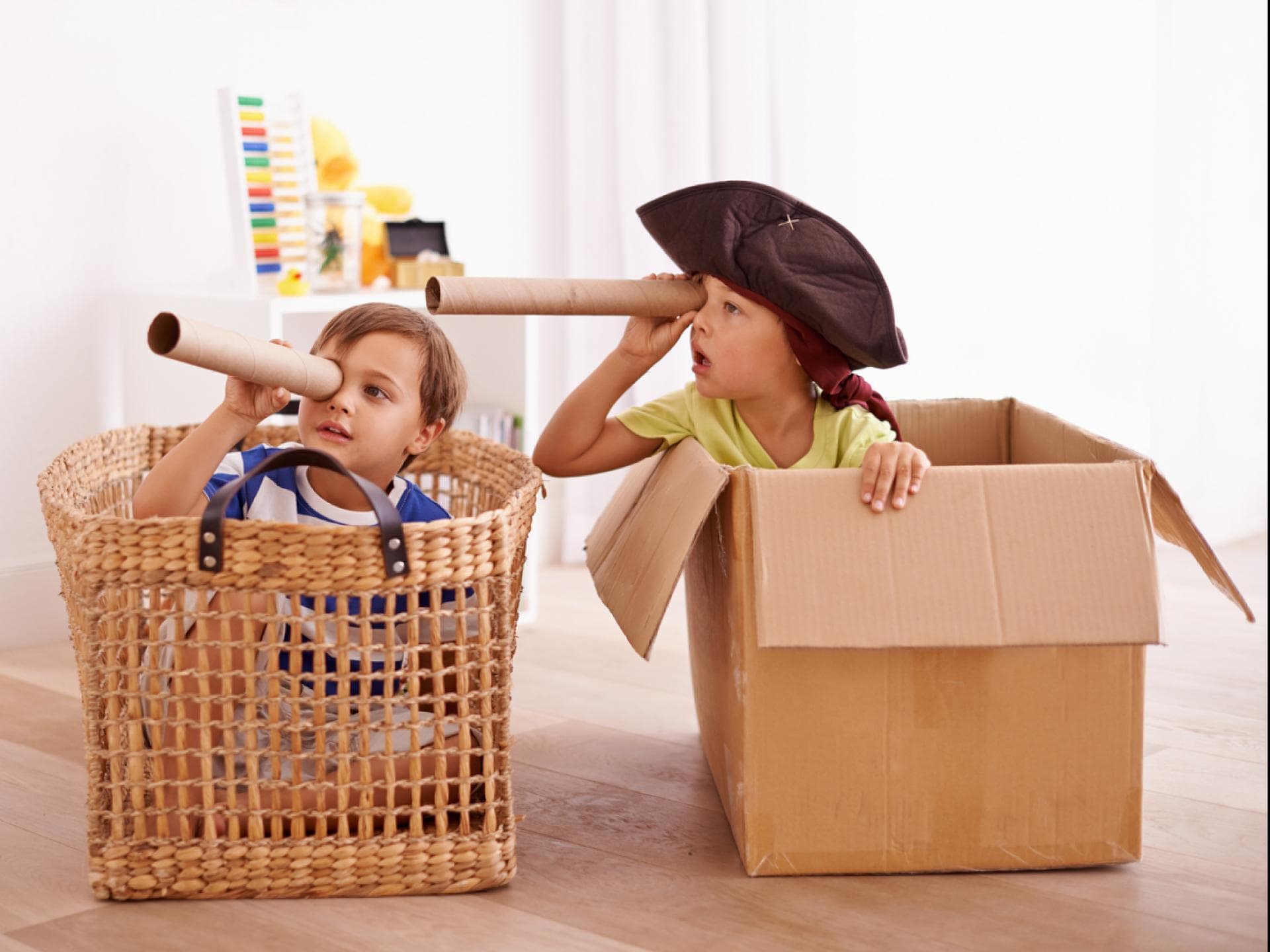 Zwei Kinder spielen in Korb und Karton Piraten. Zwei Kinder spielen in Korb und Karton Piraten.