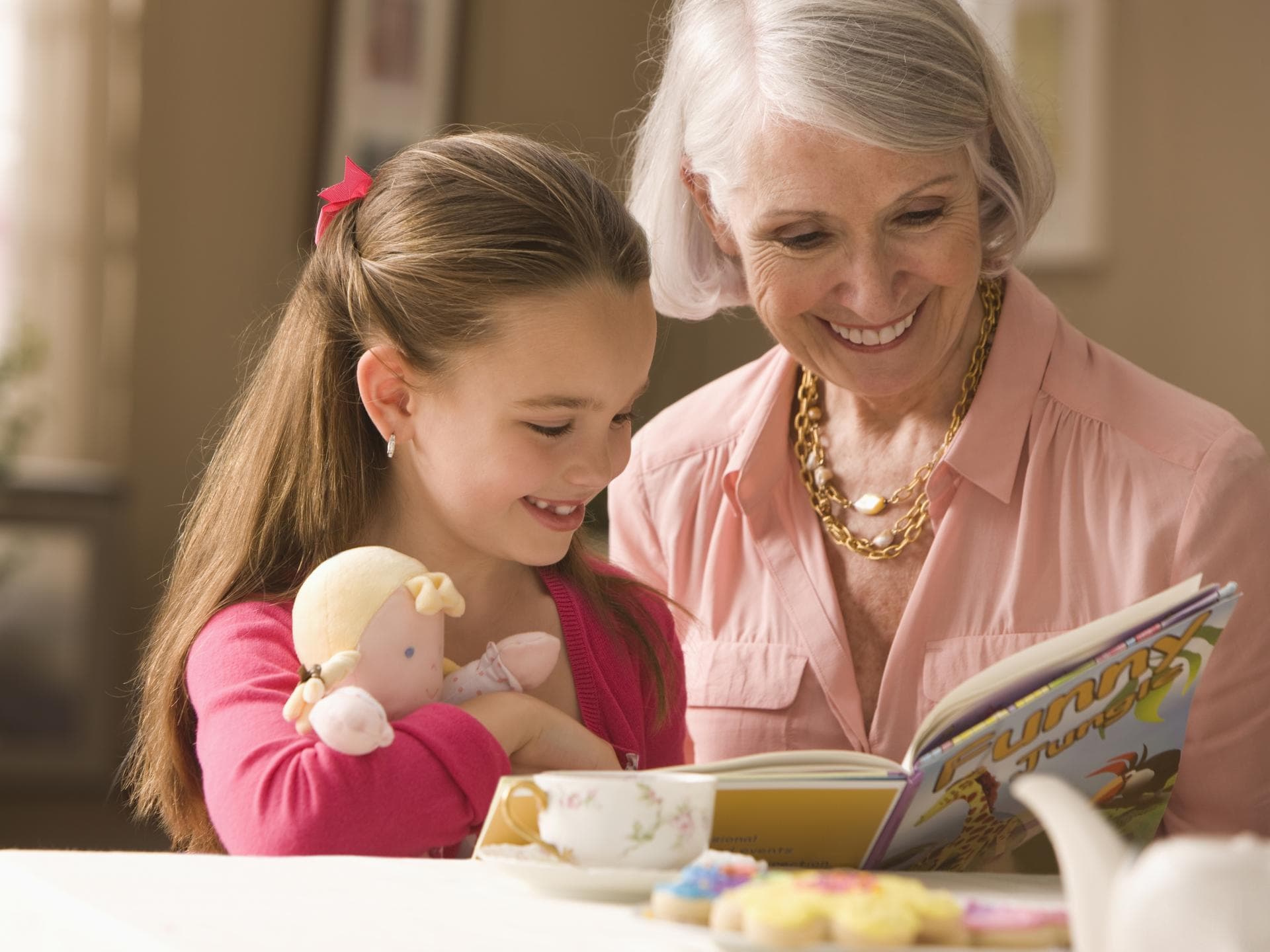 Oma schaut mit Enkelin ein Buch an. Oma schaut mit Enkelin ein Buch an.