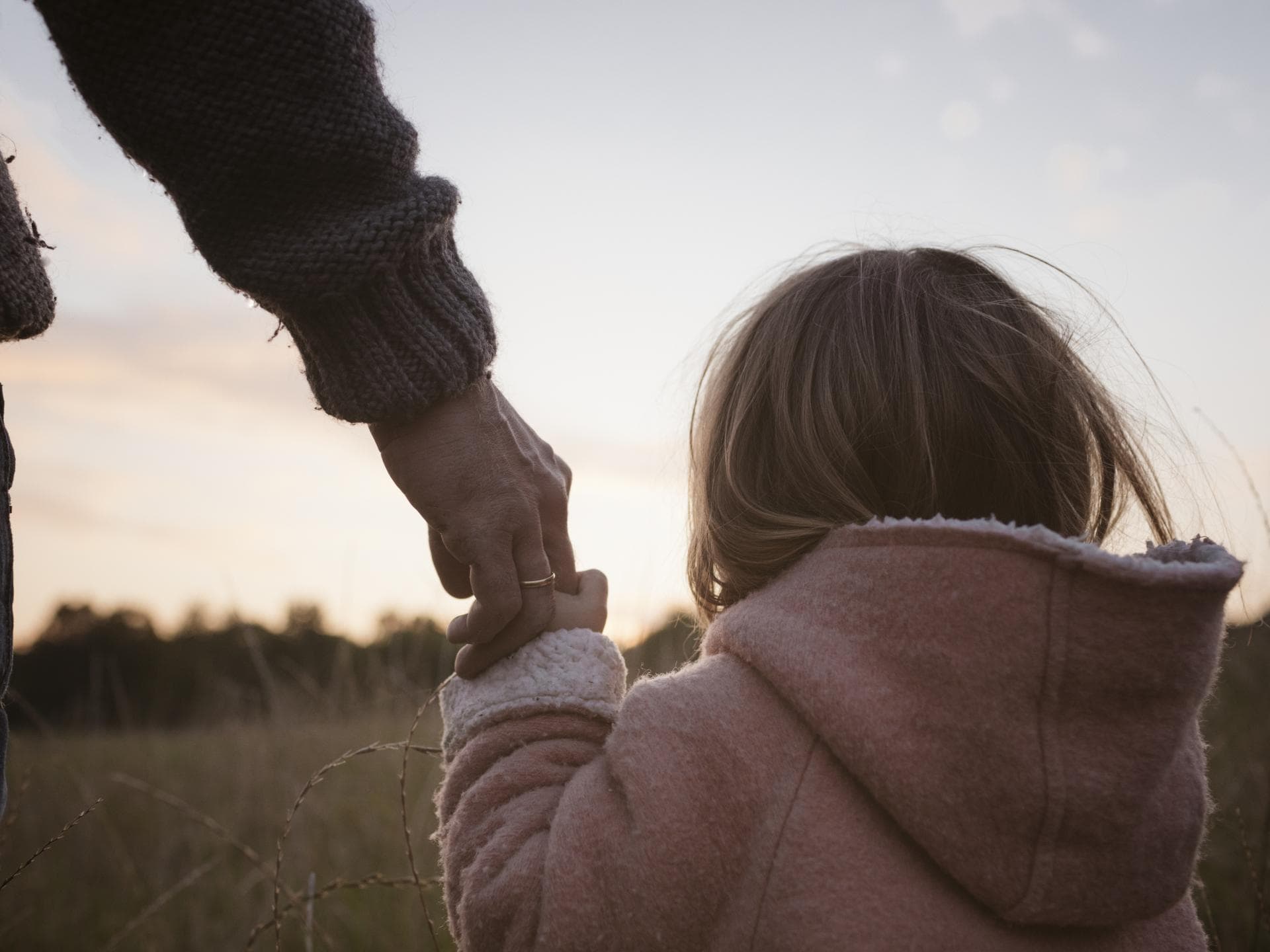Vater hält die Hand seiner Tochter.