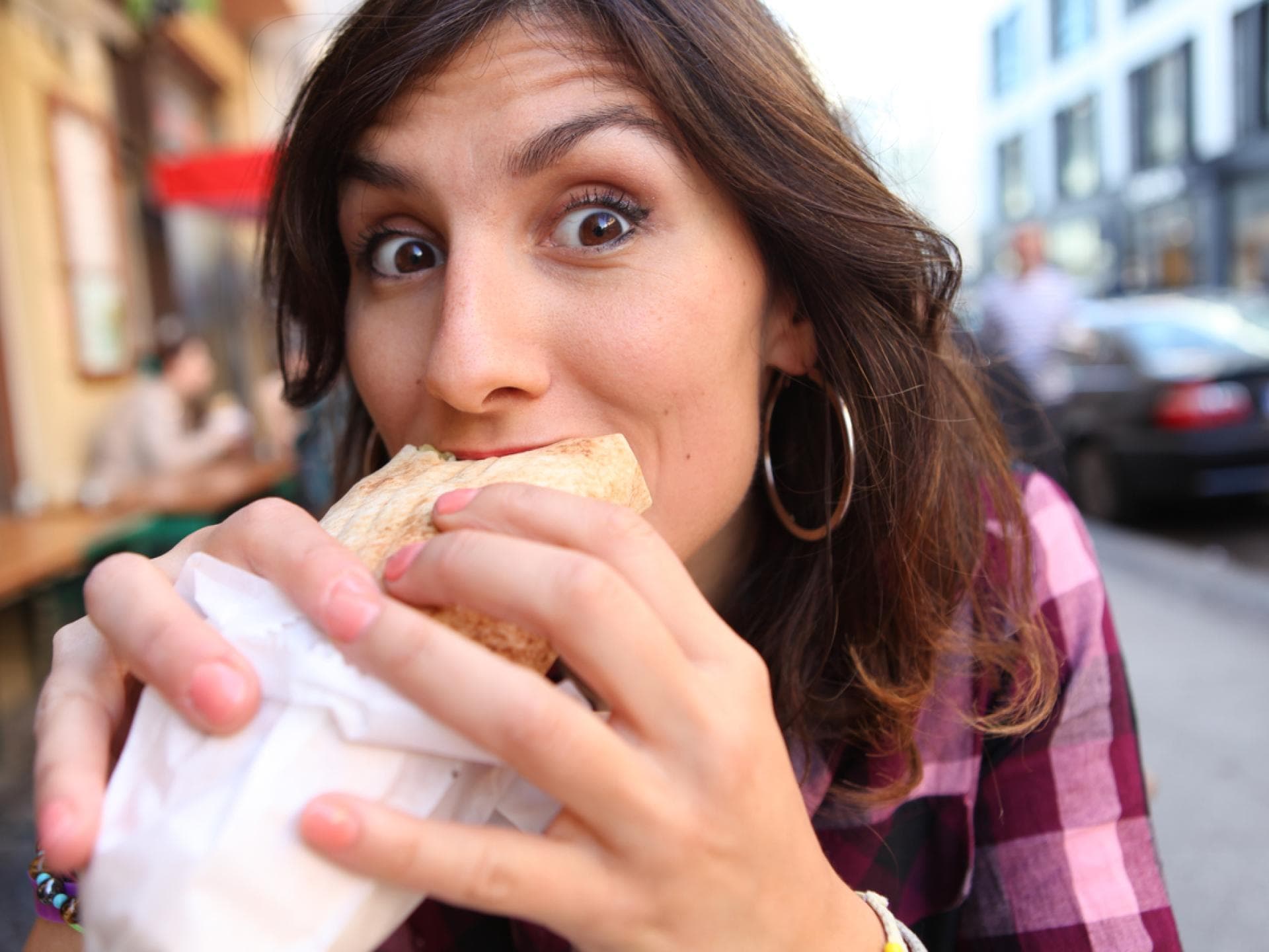 Eine schwangere Frau beißt genüsslich in einen Döner. 