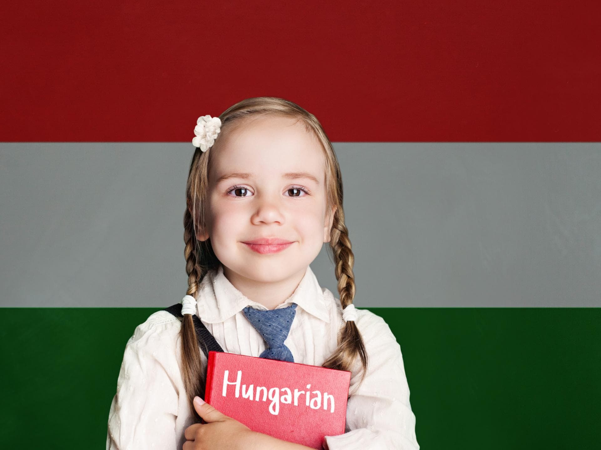 Kleines Mädchen mit Zöpfen vor der ungarischen Flagge.