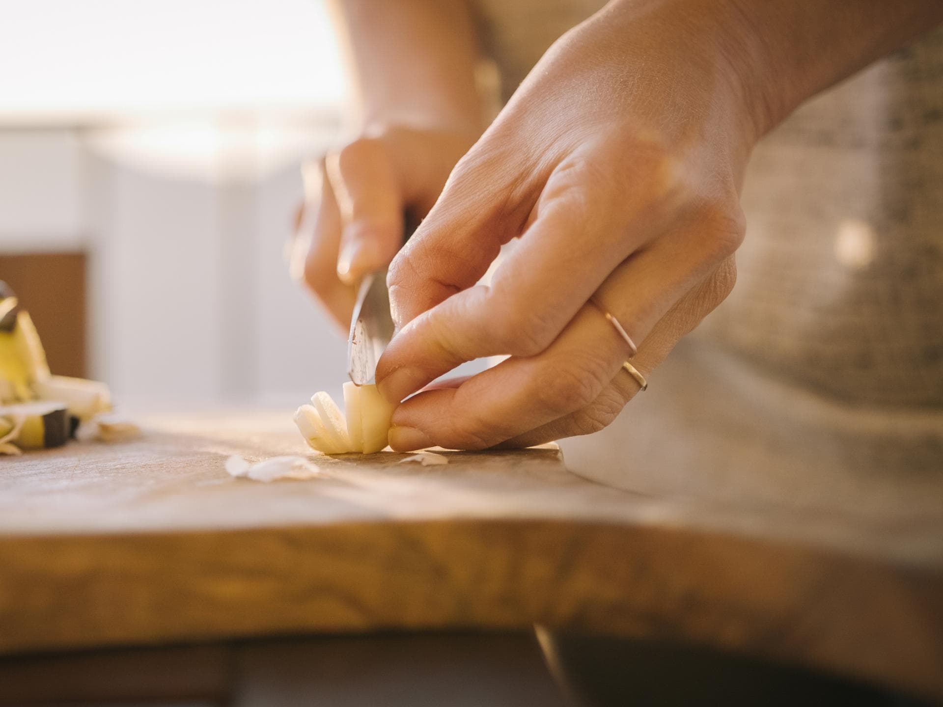 Eine Frau schneidet Knoblauch in Scheiben.