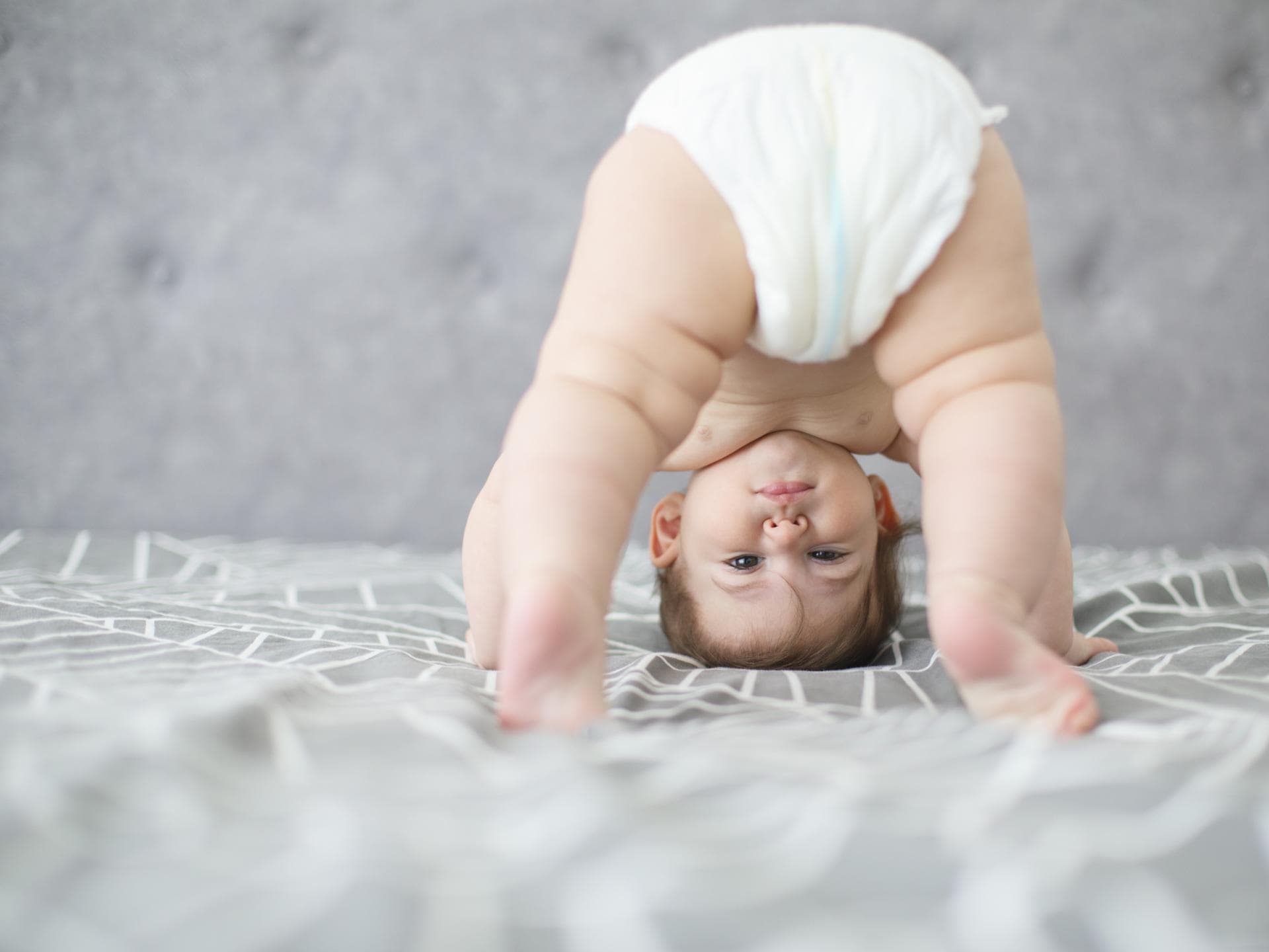 Männernamen können auch für Mädchen eine süße Idee sein. Baby steht auf dem Kopf.
