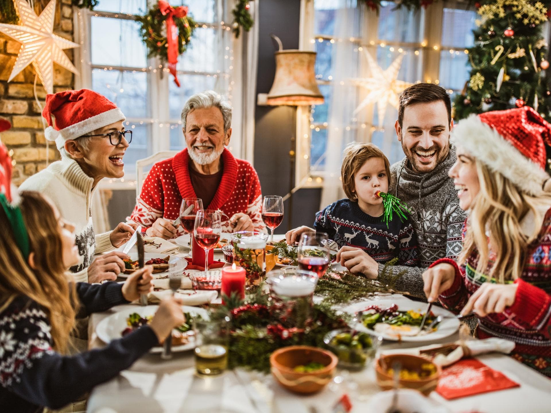 Familie sitzt Weihnachten zusammen am Tisch.