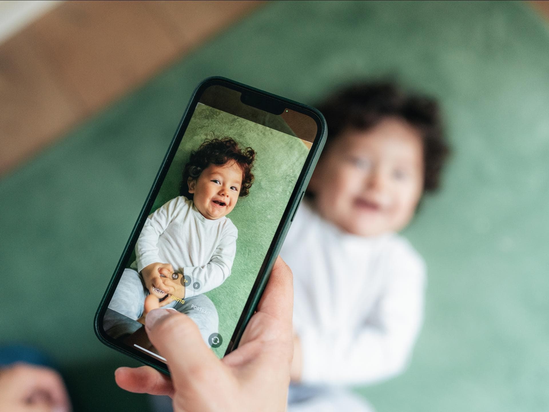 So nennen bekannte Influencerinnen ihre Babys ... Ein Baby, das mit einem Handy fotografiert wird.