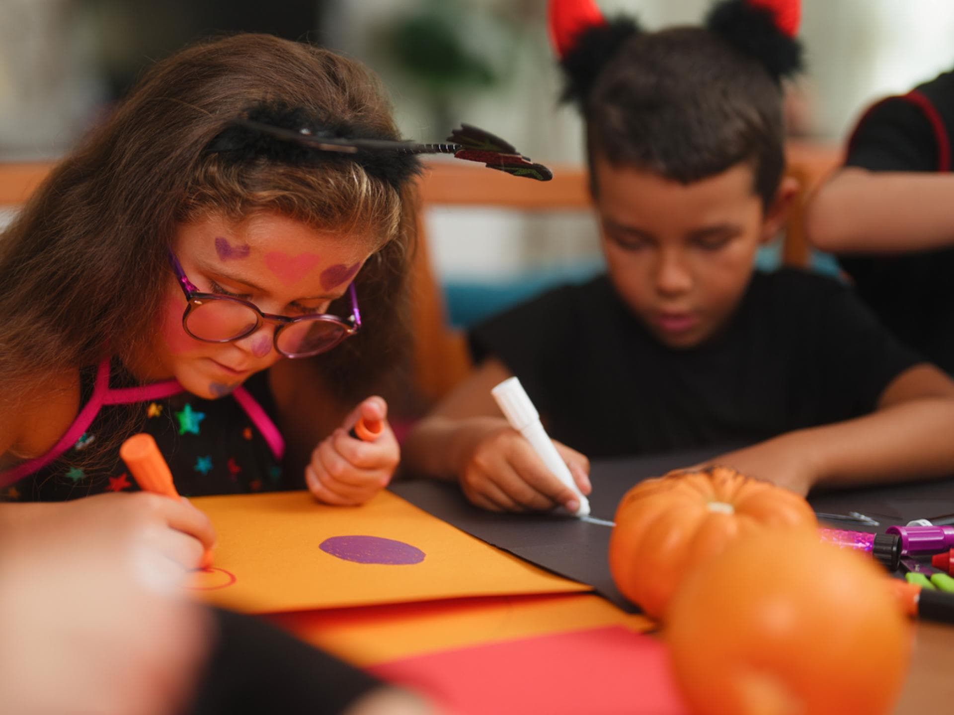 Kinder basteln zusammen eine Fledermaus-Laterne.