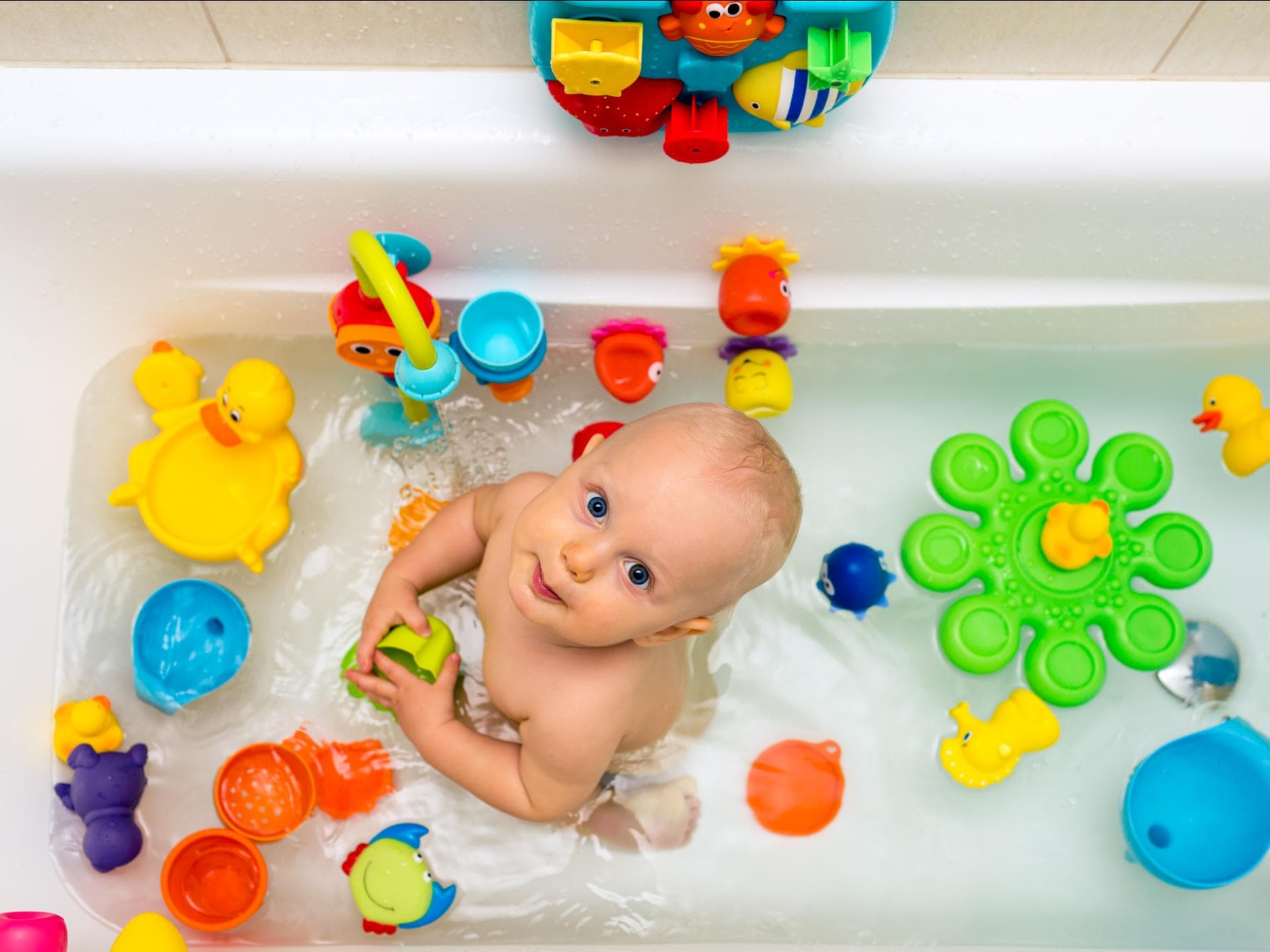 Ein kleiner Junge badet in der Badewanne mit seinem Spielzeug. Ein kleiner Junge badet in der Badewanne mit seinem Spielzeug.