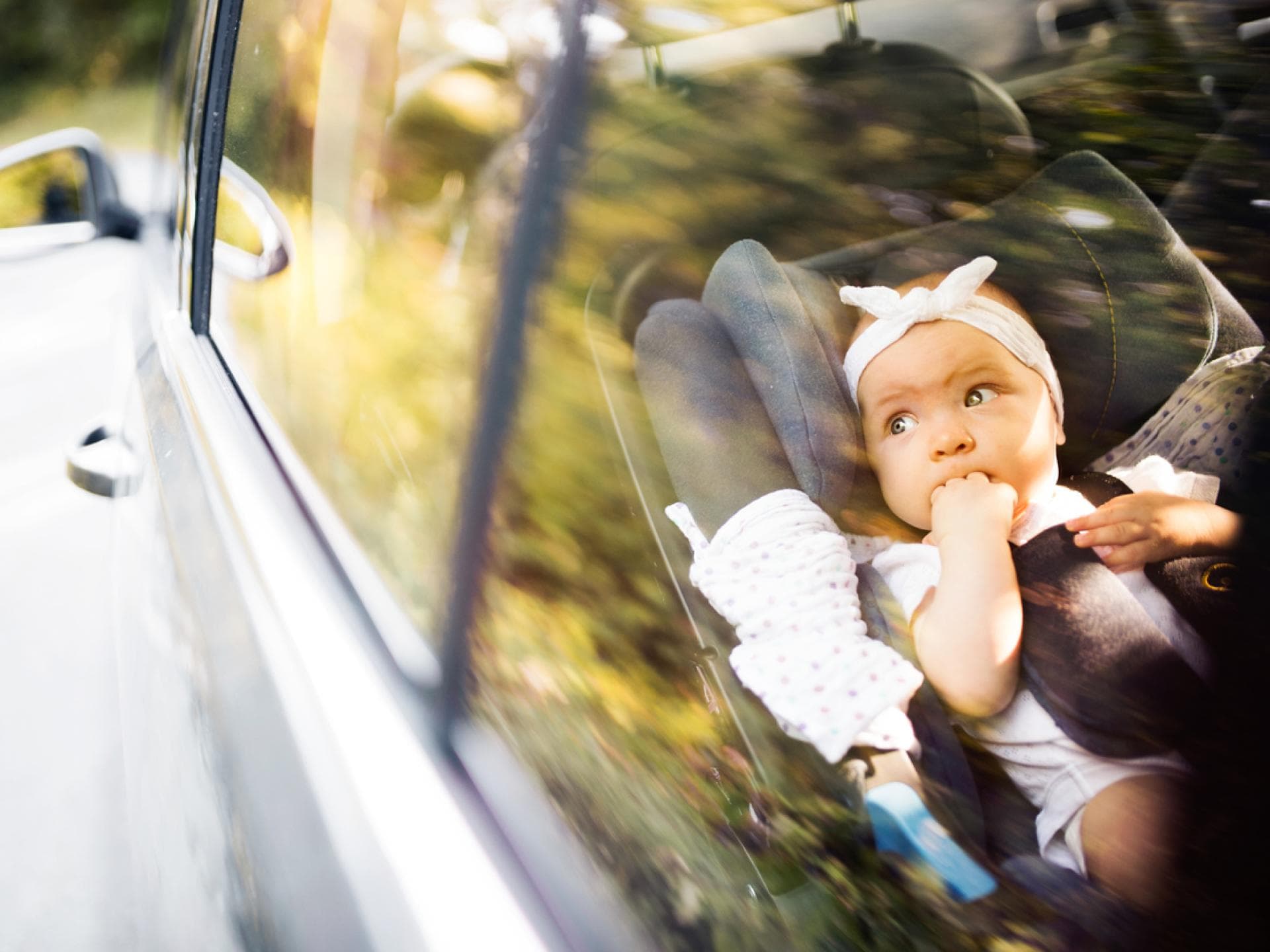 Baby liegt entspannt im Auto. Reisen mit Baby kann funktionieren – mit guter Vorbereitung!