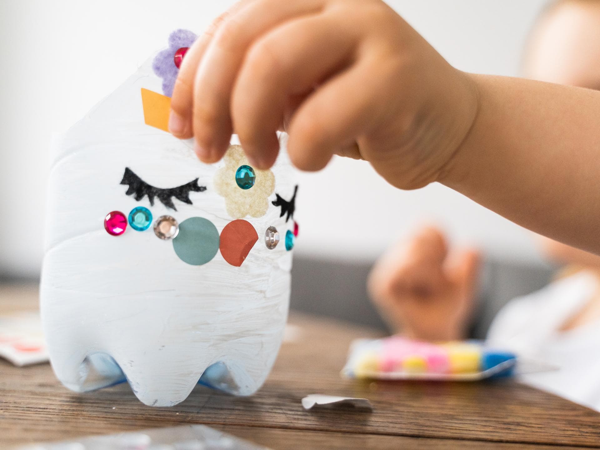 Kinderhand beklebt abgeschnittene PET-Flasche als Laterne. Kinderhand beklebt abgeschnittene PET-Flasche als Laterne.