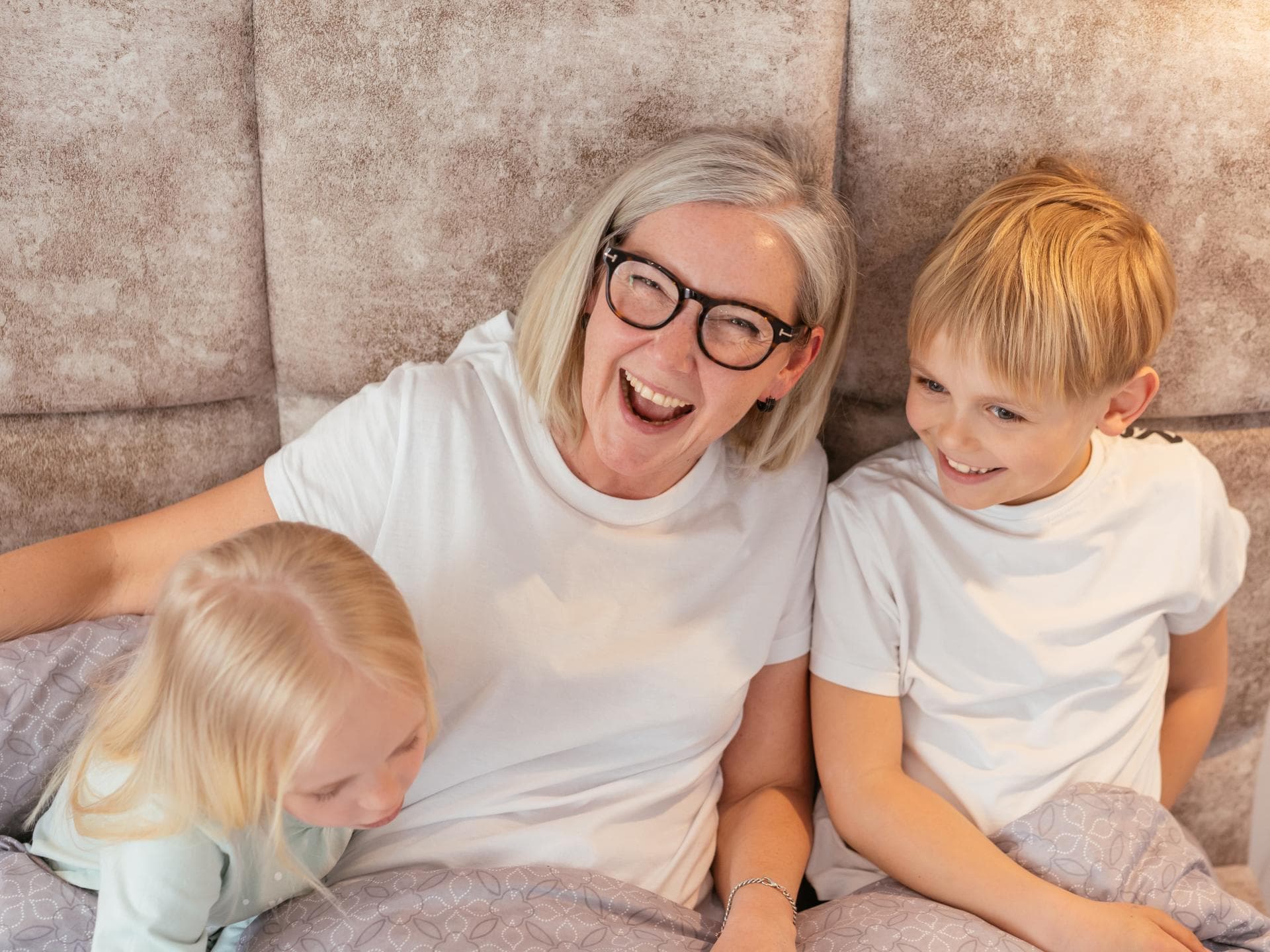 Oma lacht mit ihren beiden Enkeln.