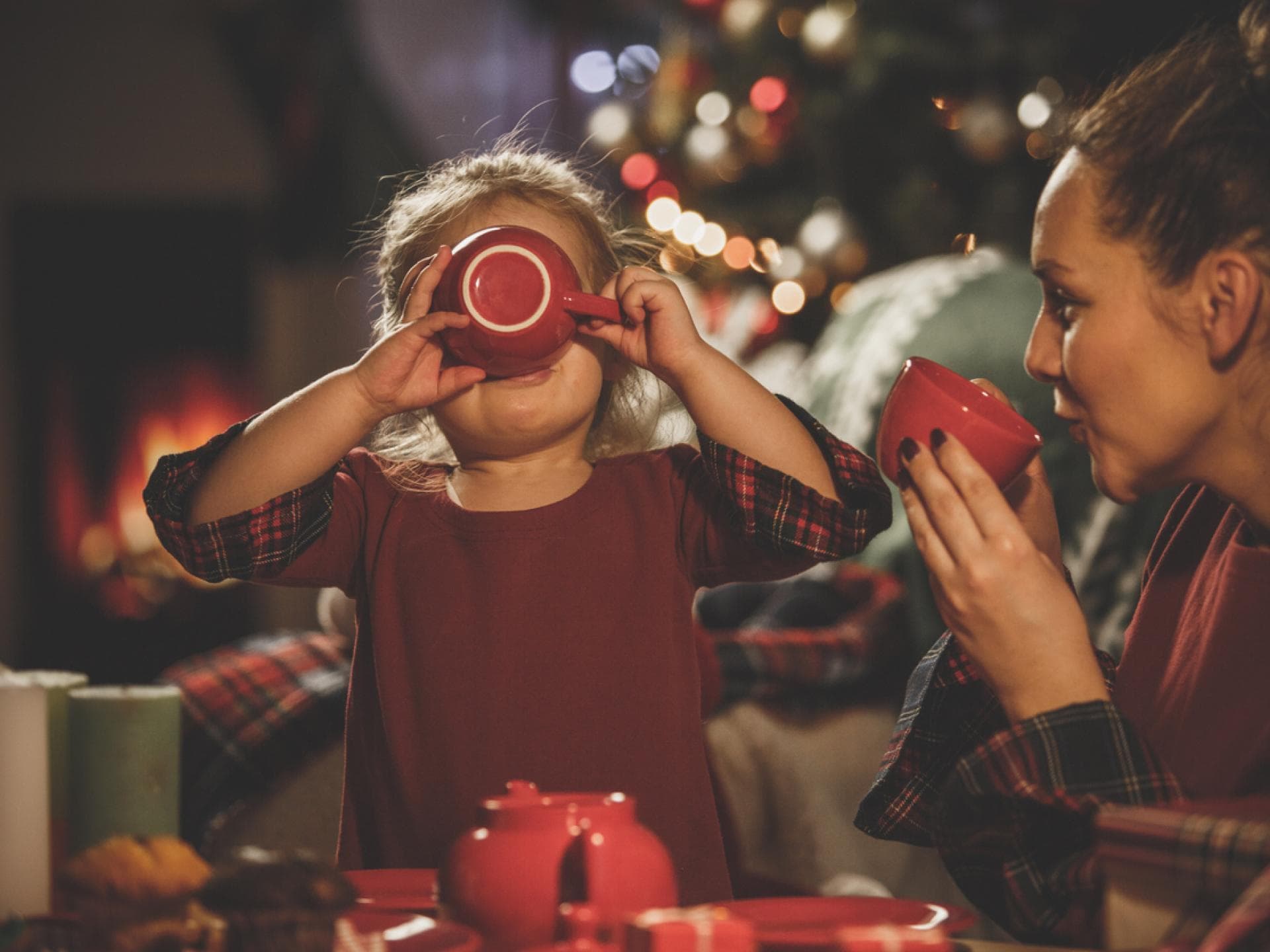 Kleines Mädchen trinkt mit ihrer Mama alkoholfreien Kinderpunsch zur Weihnachtszeit. Kleines Mädchen trinkt mit ihrer Mama alkoholfreien Kinderpunsch zur Weihnachtszeit.
