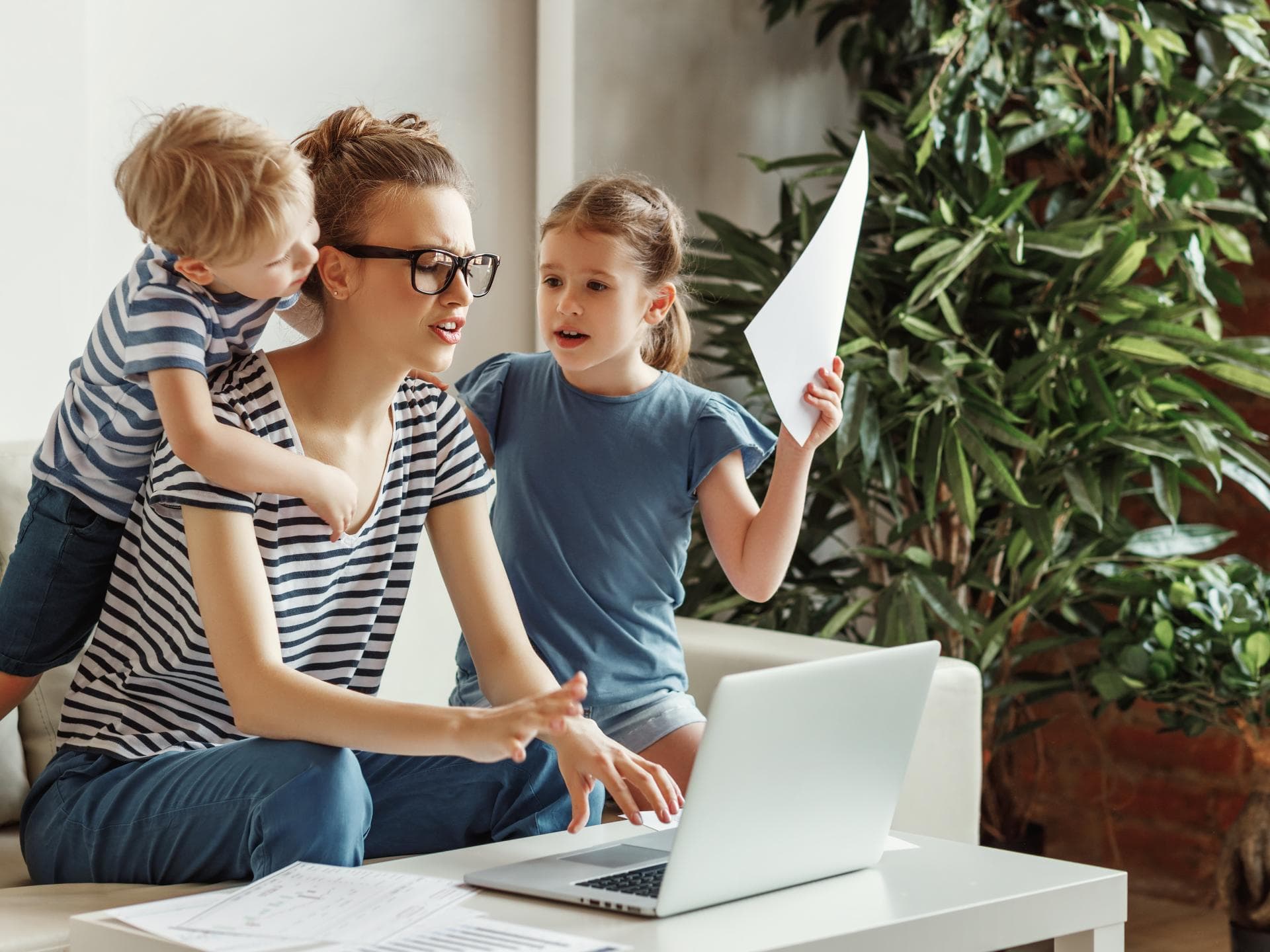 Frau am Laptop mit zwei Kindern.