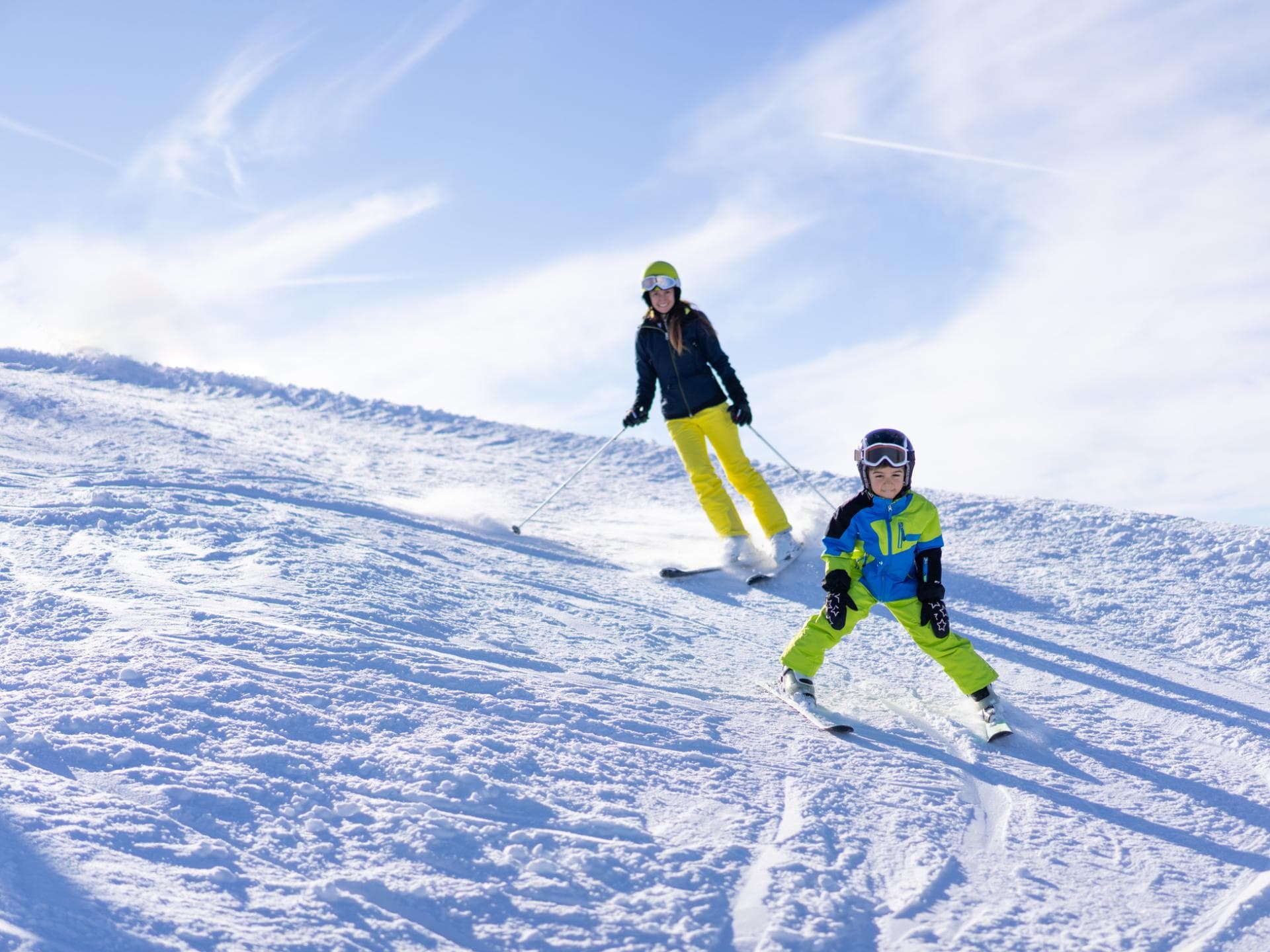 Eine Mutter bringt ihrem Sohn das Skifahren bei. 
