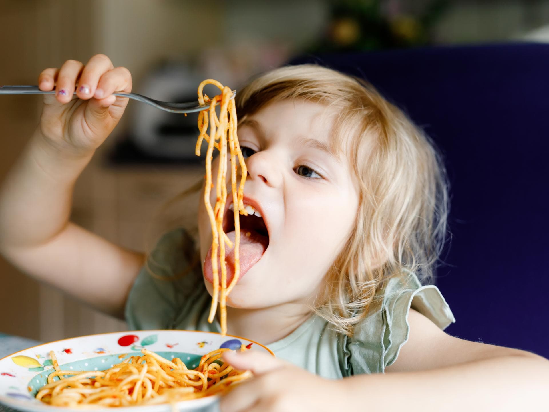 Essen mit Kindern ist für viele Familien ein schwieriges Thema. Kind isst Spaghetti.