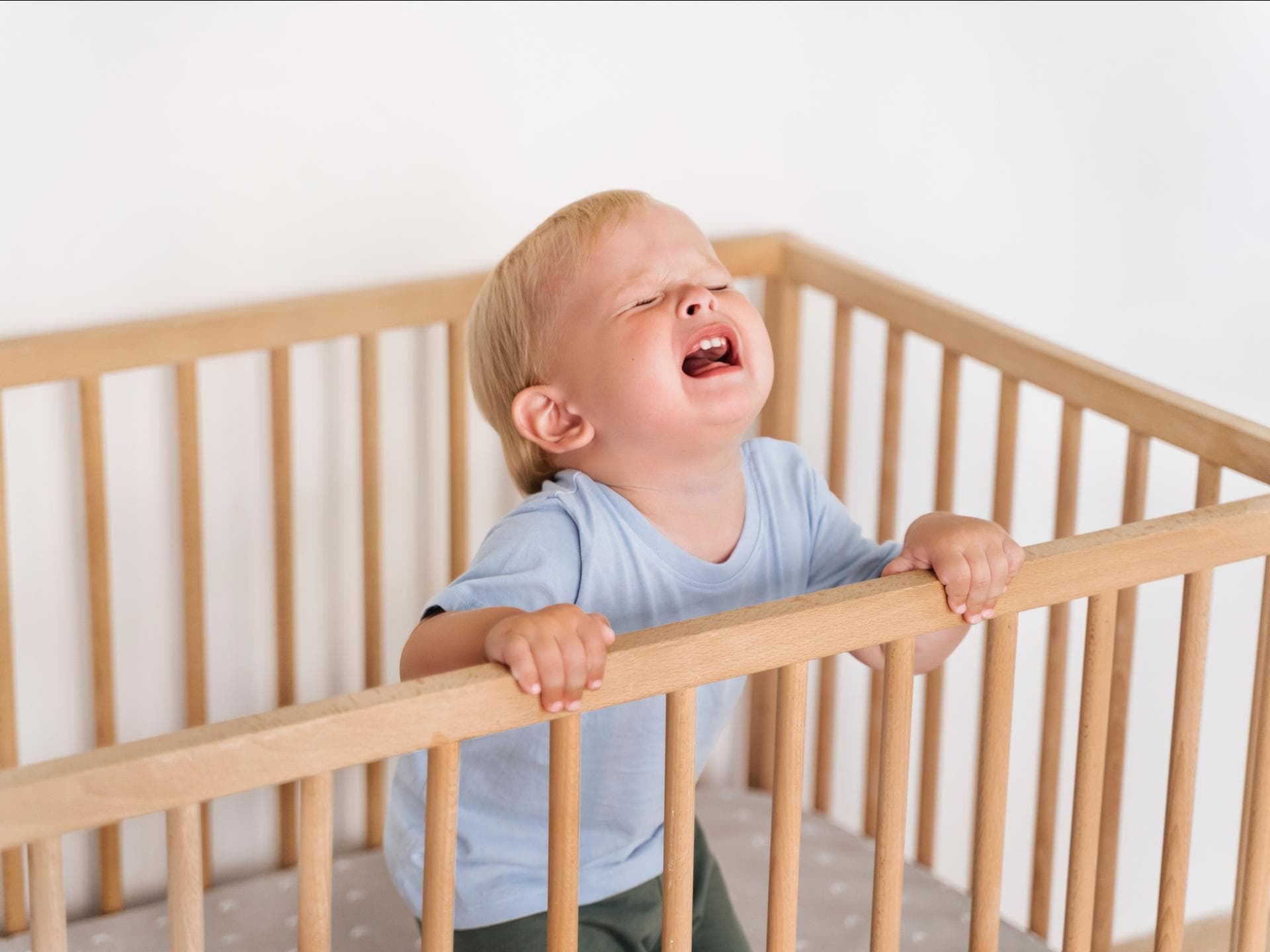 Ein Kleinkind wird im Kinderbett wütend