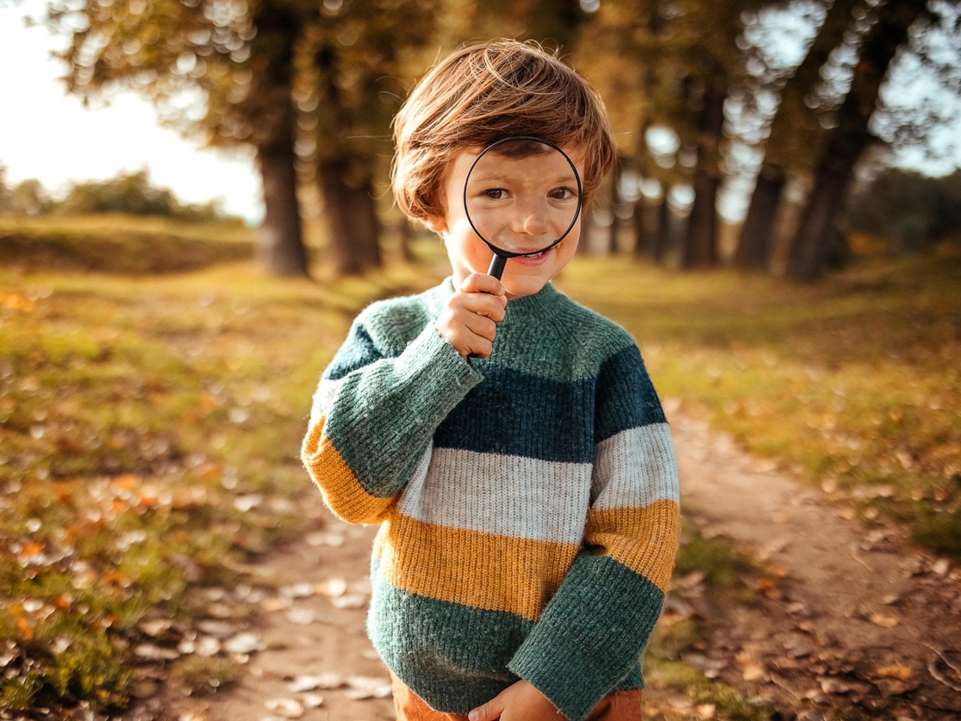 Studien ergaben neue Erkenntnisse darum, wie Kinder gesund heranwachsen. Kleiner Junge guckt durch eine Lupe.