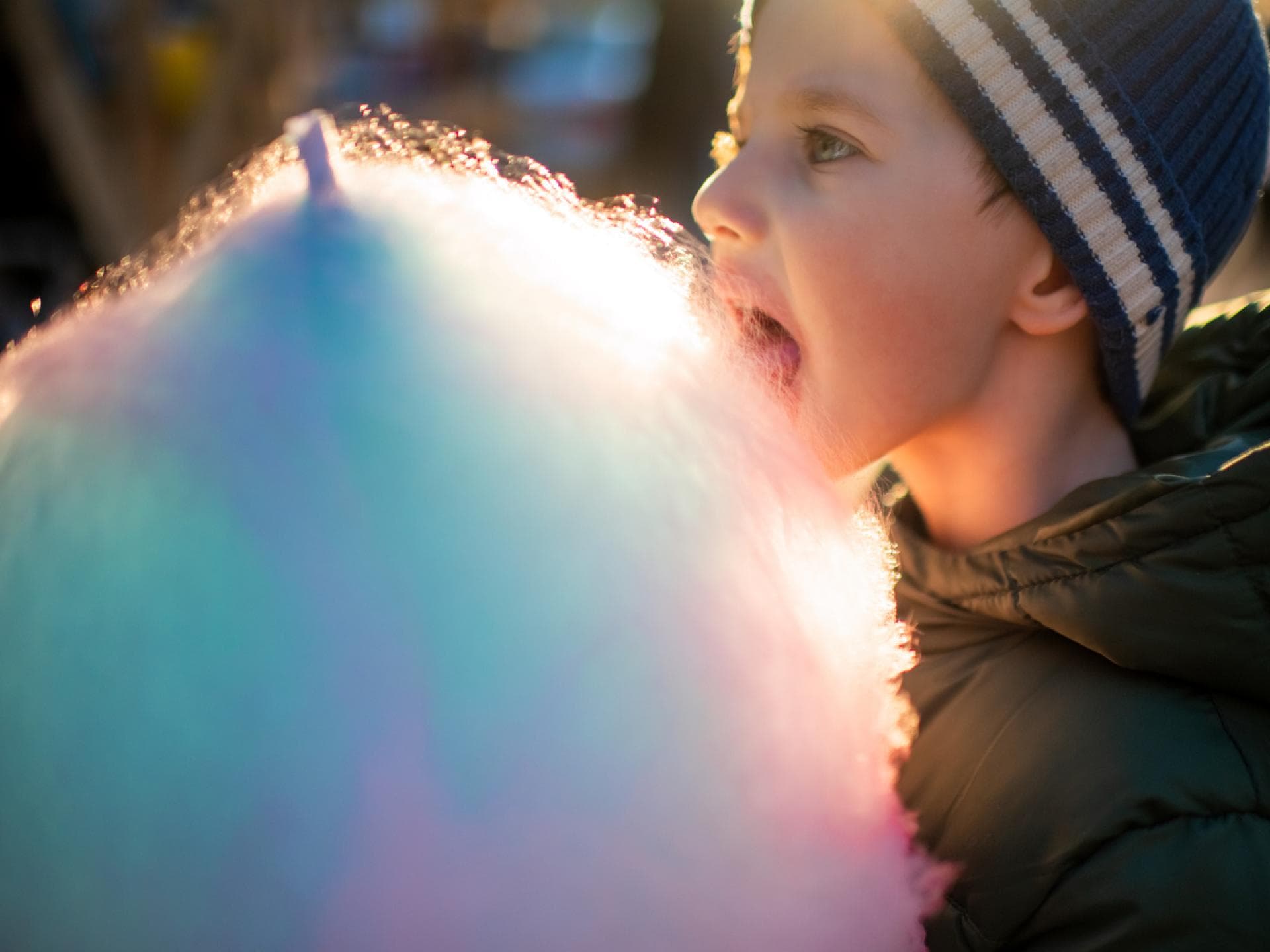 Kleiner Junge isst Zuckerwatte auf dem Weihnachtsmarkt. Kleiner Junge isst Zuckerwatte auf dem Weihnachtsmarkt.