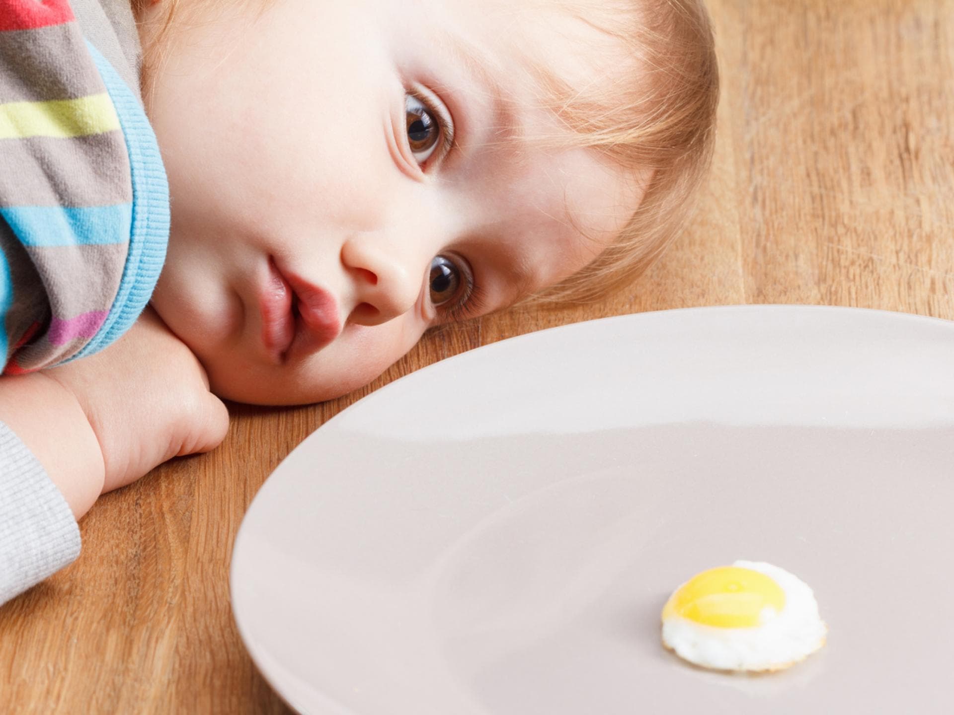 Baby schaut sich ein Spiegelei genau an. Baby schaut sich ein Spiegelei genau an.