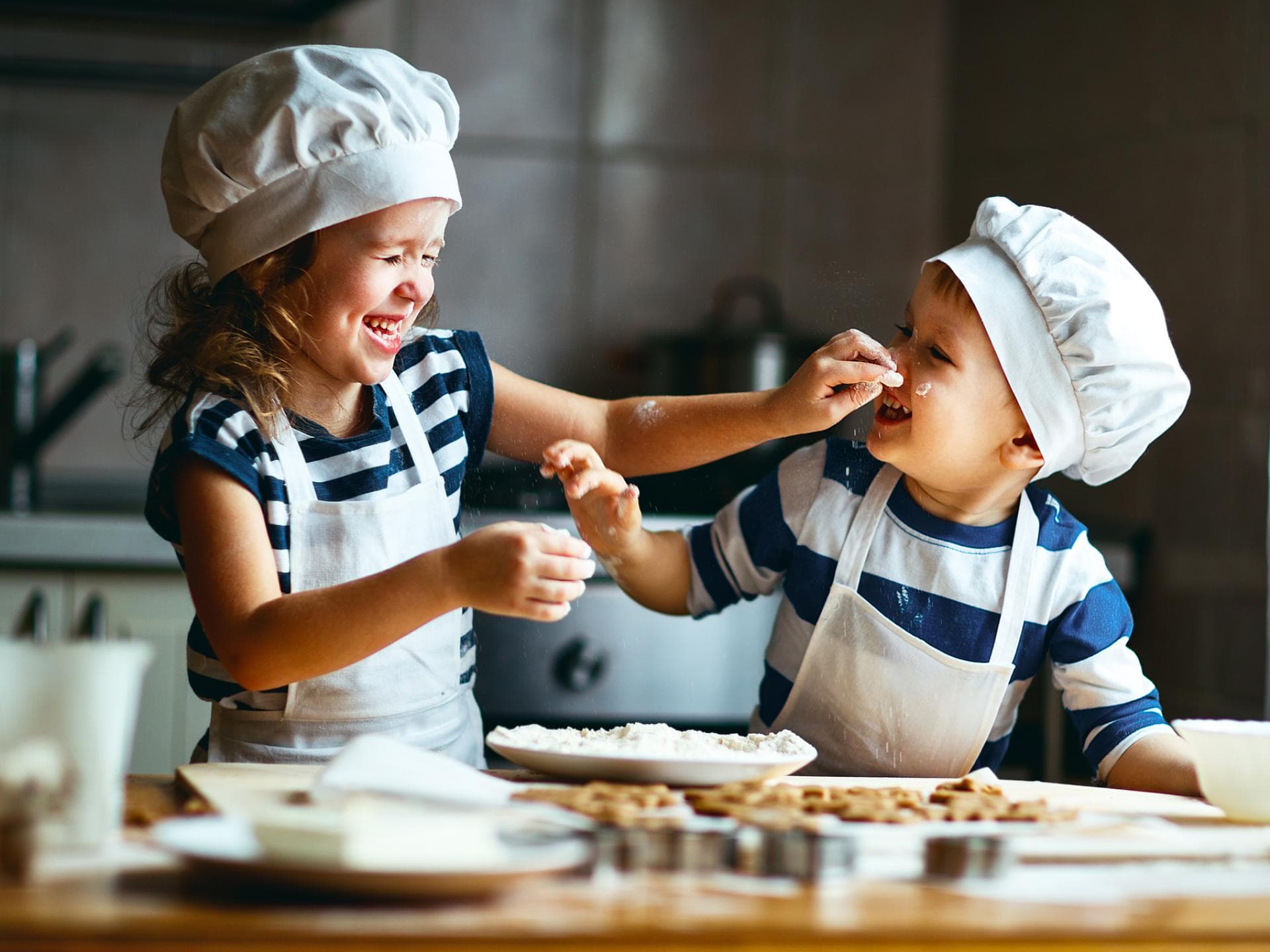 Zwei kleine, niedliche Kinder backen Kekse.