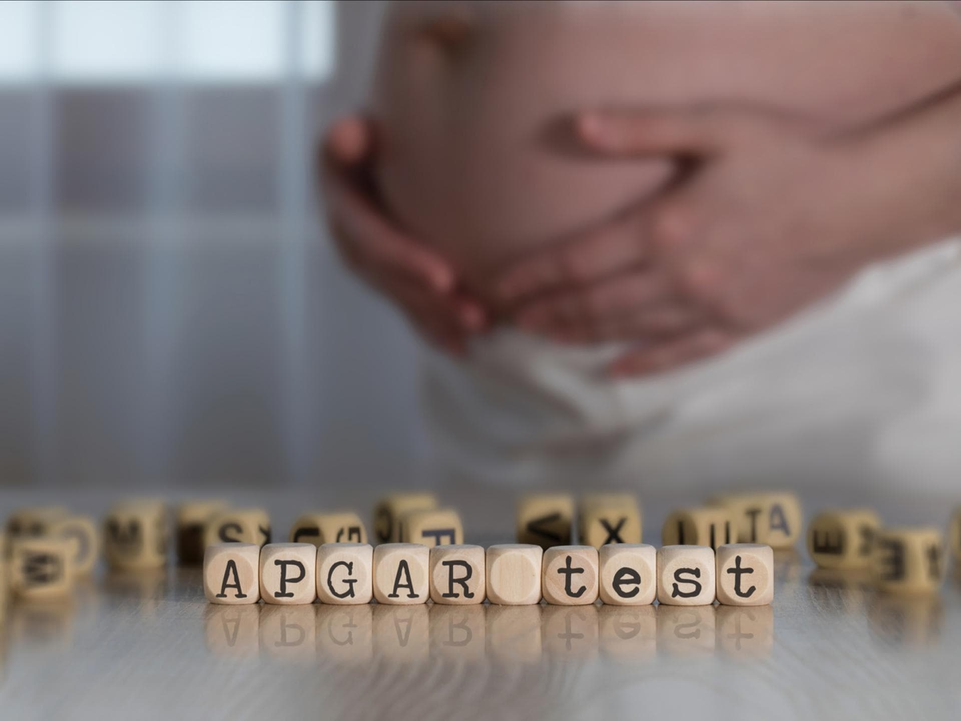 Schwangere Frau hinter dem Wort "Apgar-Test".