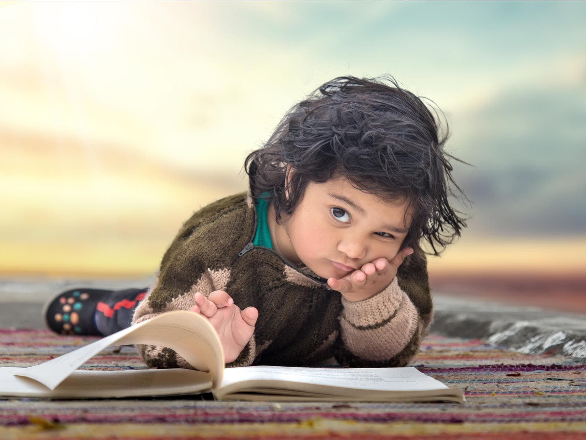 iStock-Umesh Negi Ernstes Kind schaut von einem Buch hoch.