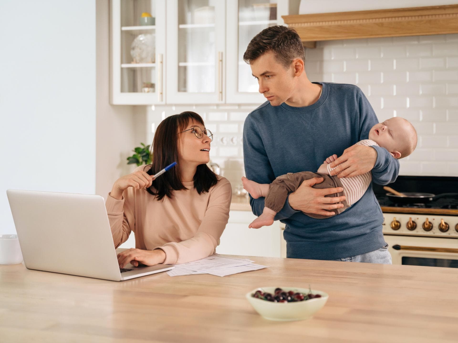 Junge Eltern mit Baby besprechen das Thema Finanzen.