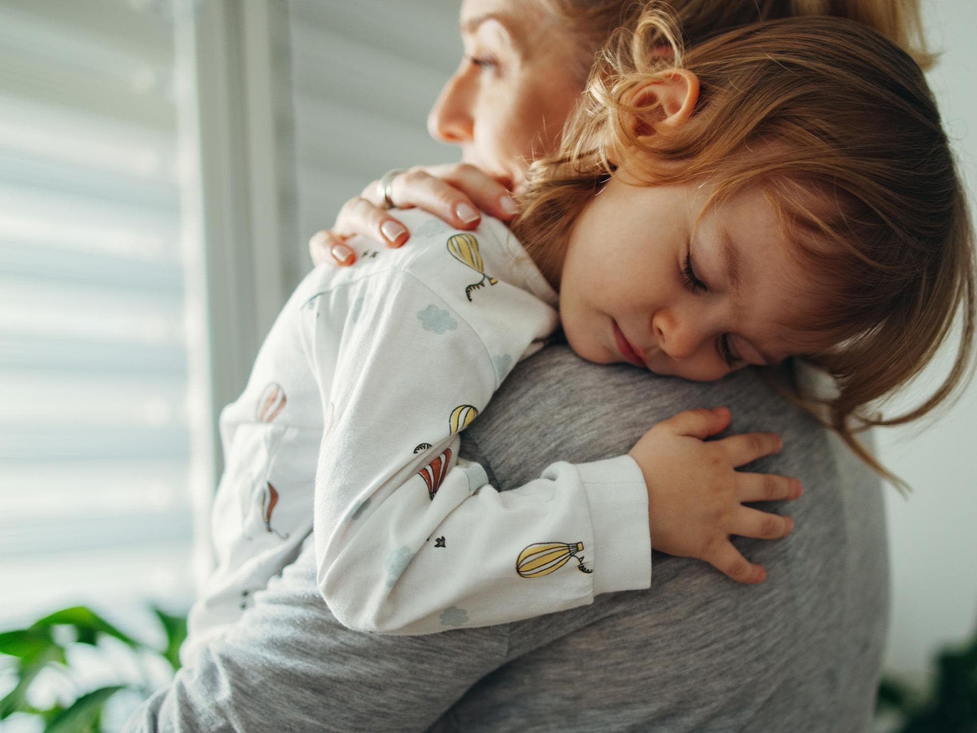 Kind kuschelt mit seiner Mutter.