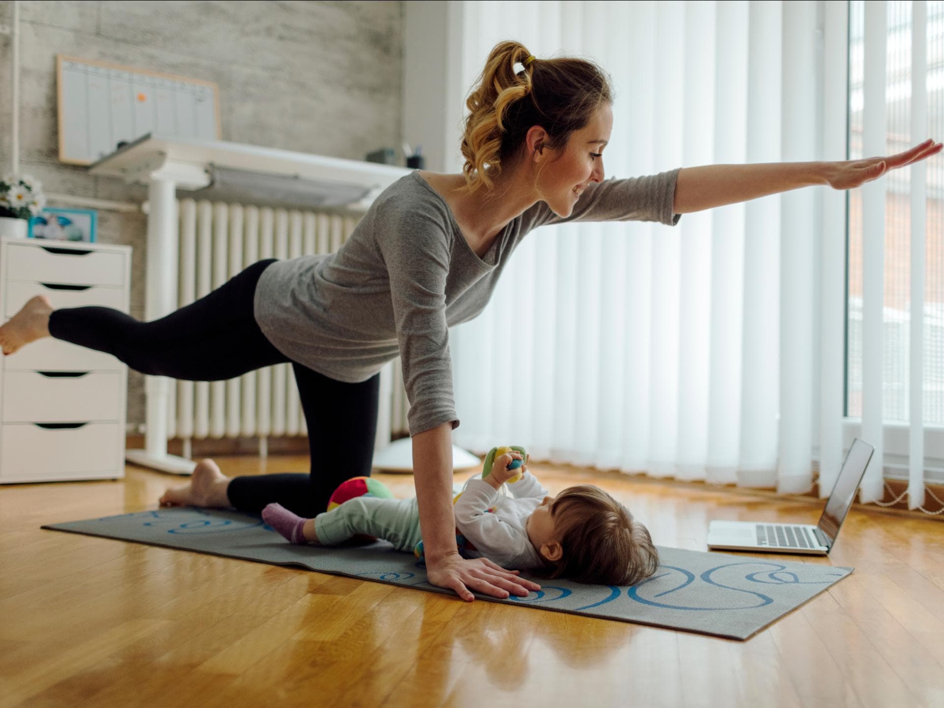 Eine Mama macht nach der Geburt Beckenbodentraining mit ihrem Baby. 