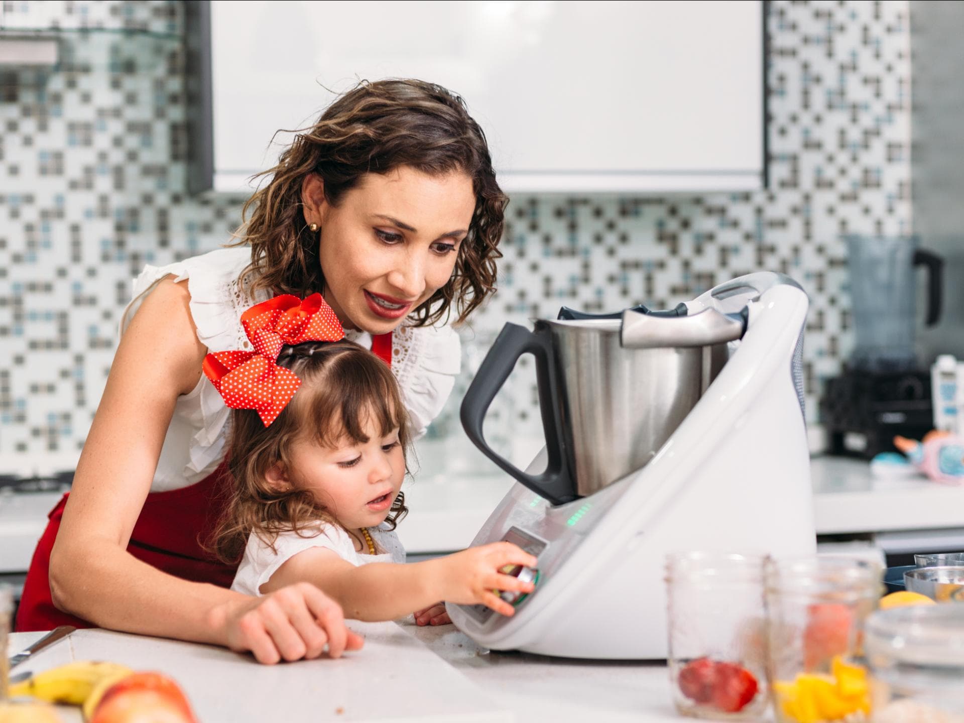 Mutter und Tochter bedienen eine Küchenmaschine. Mutter und Tochter bedienen eine Küchenmaschine.